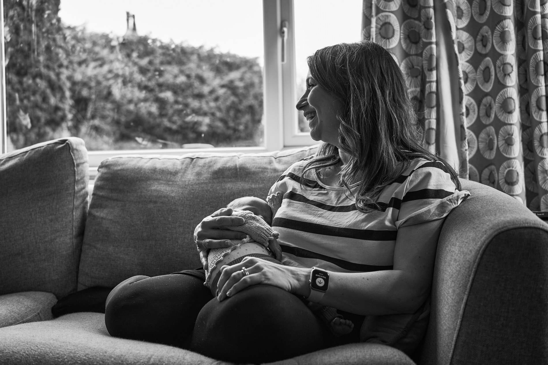 a candid photo of mum laughing holding her baby