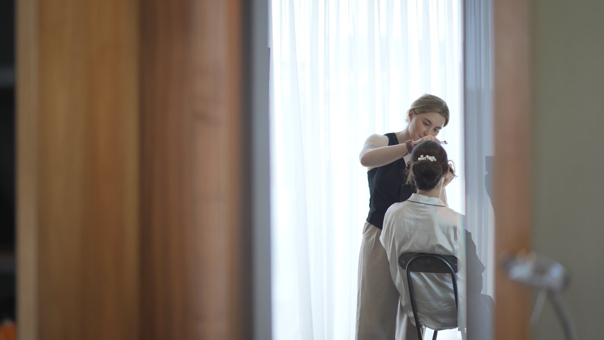 Kirsty and Josh Sefton Palm House Wedding Video 1 a bride sits with her makeup artist in a suite at Hilton Liverpool