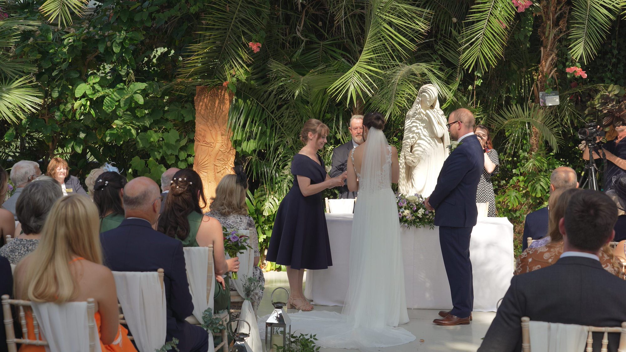 Kirsty and Josh Sefton Palm House Wedding Video 14 a grooms maid hands over the wedding ring during ceremony