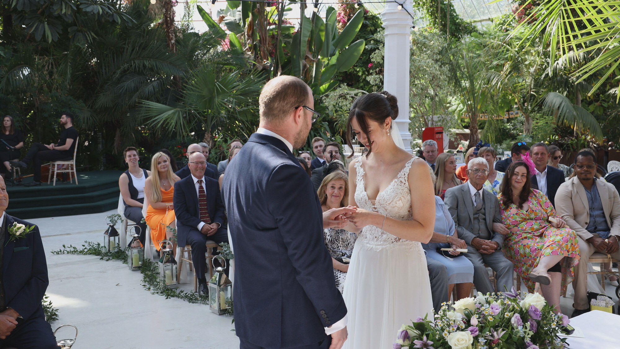 Kirsty and Josh Sefton Palm House Wedding Video 15 a bride puts on her grooms ring at Sefton Park Palm House wedding ceremony