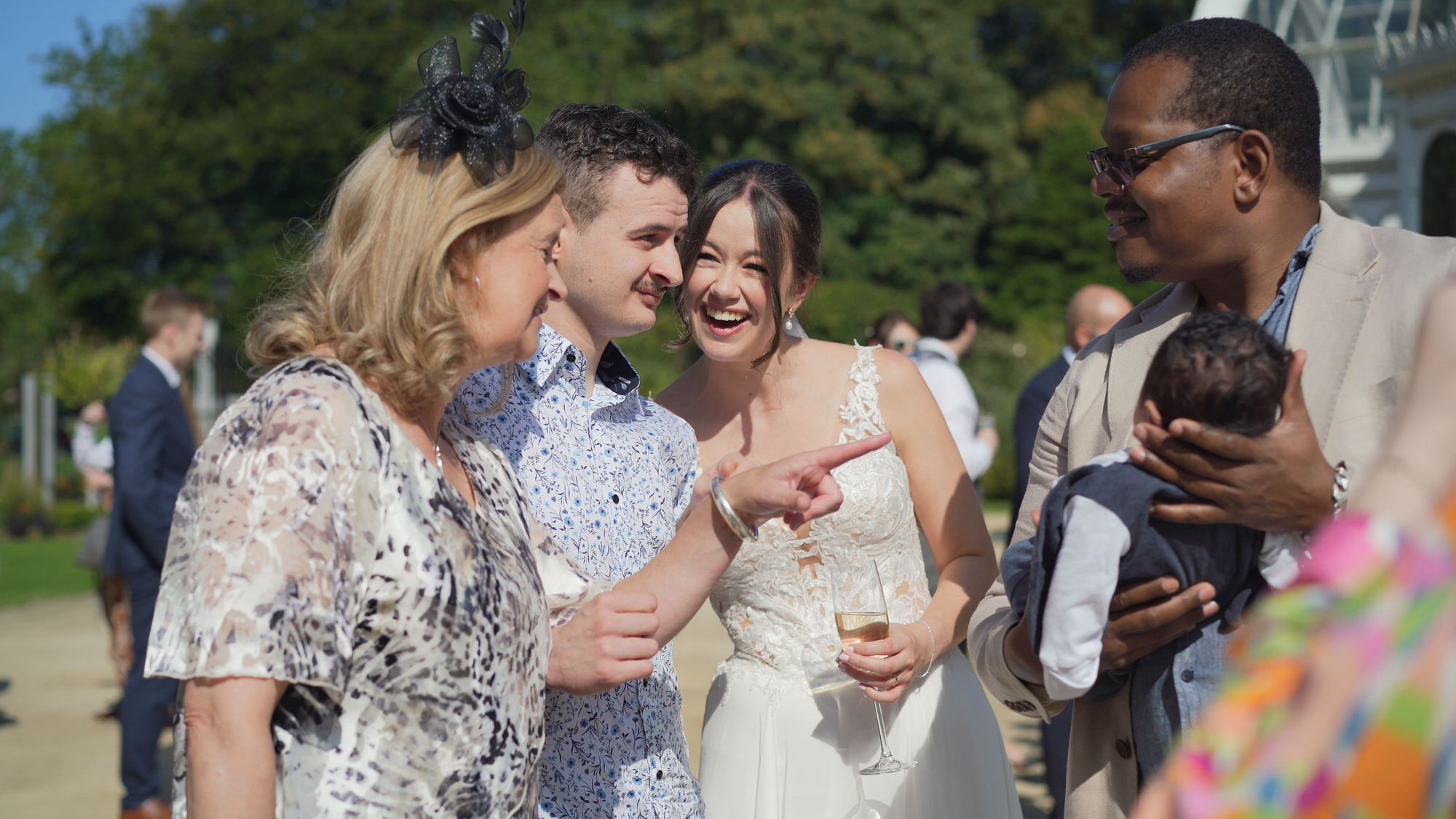 Kirsty and Josh Sefton Palm House Wedding Video 19 guests smile at a newborn baby during wedding reception