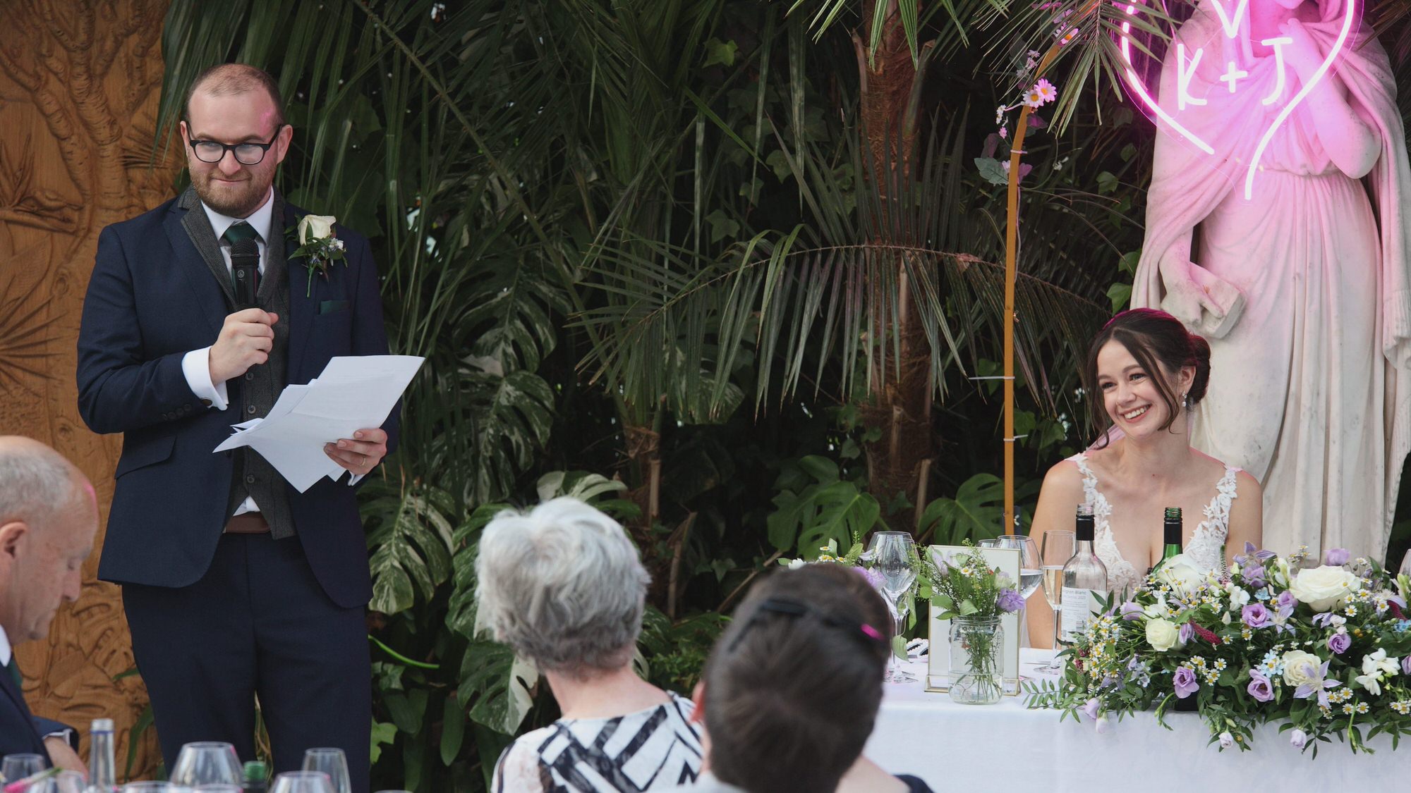 Kirsty and Josh Sefton Palm House Wedding Video 29 the groom stands to give his speech at Sefton Park Palm House Liverpool