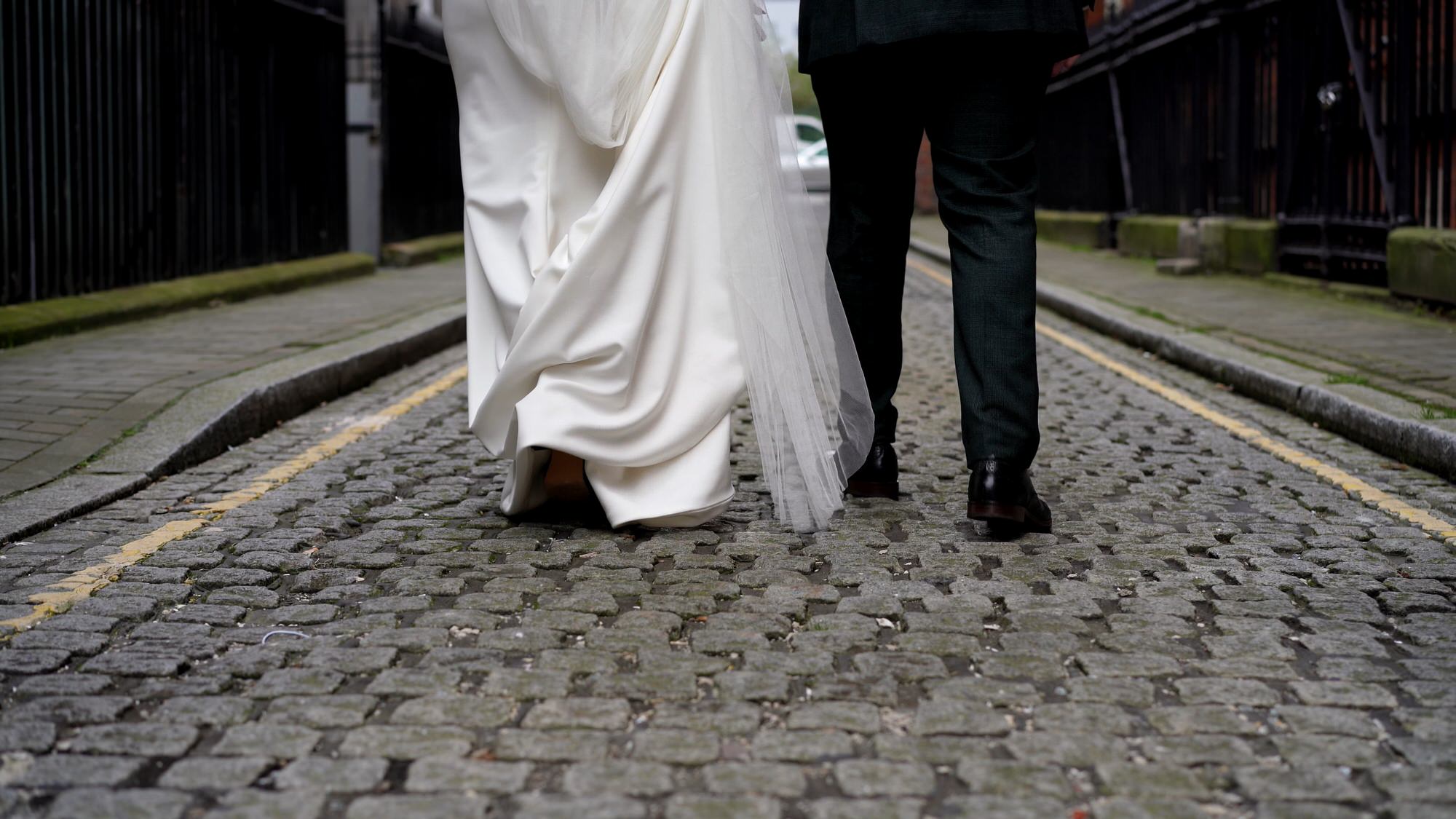 a unique video still of the couples feet walking down a cobbled street in Liverpool