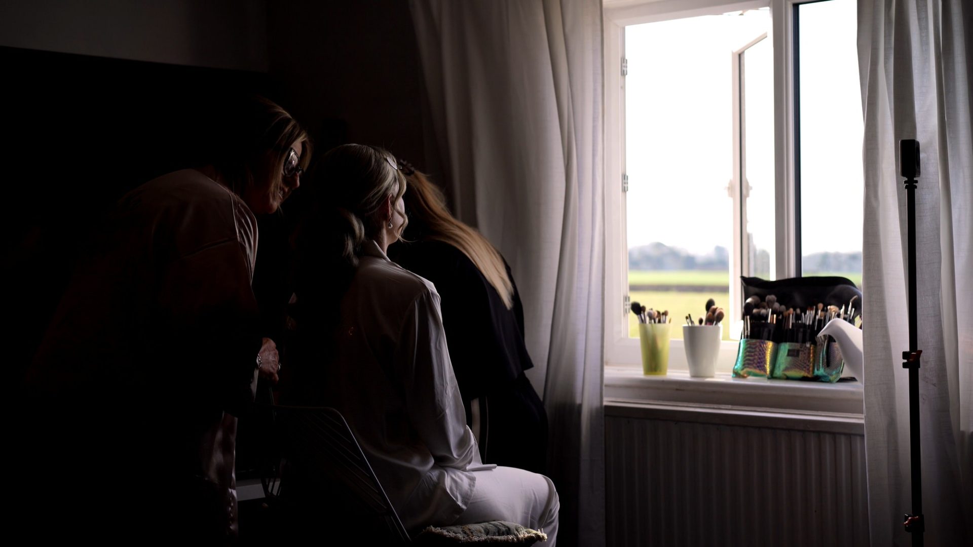 a candid video still of a bride with her Mum and Makeup artist in the dressing room at Larkspur Lodge