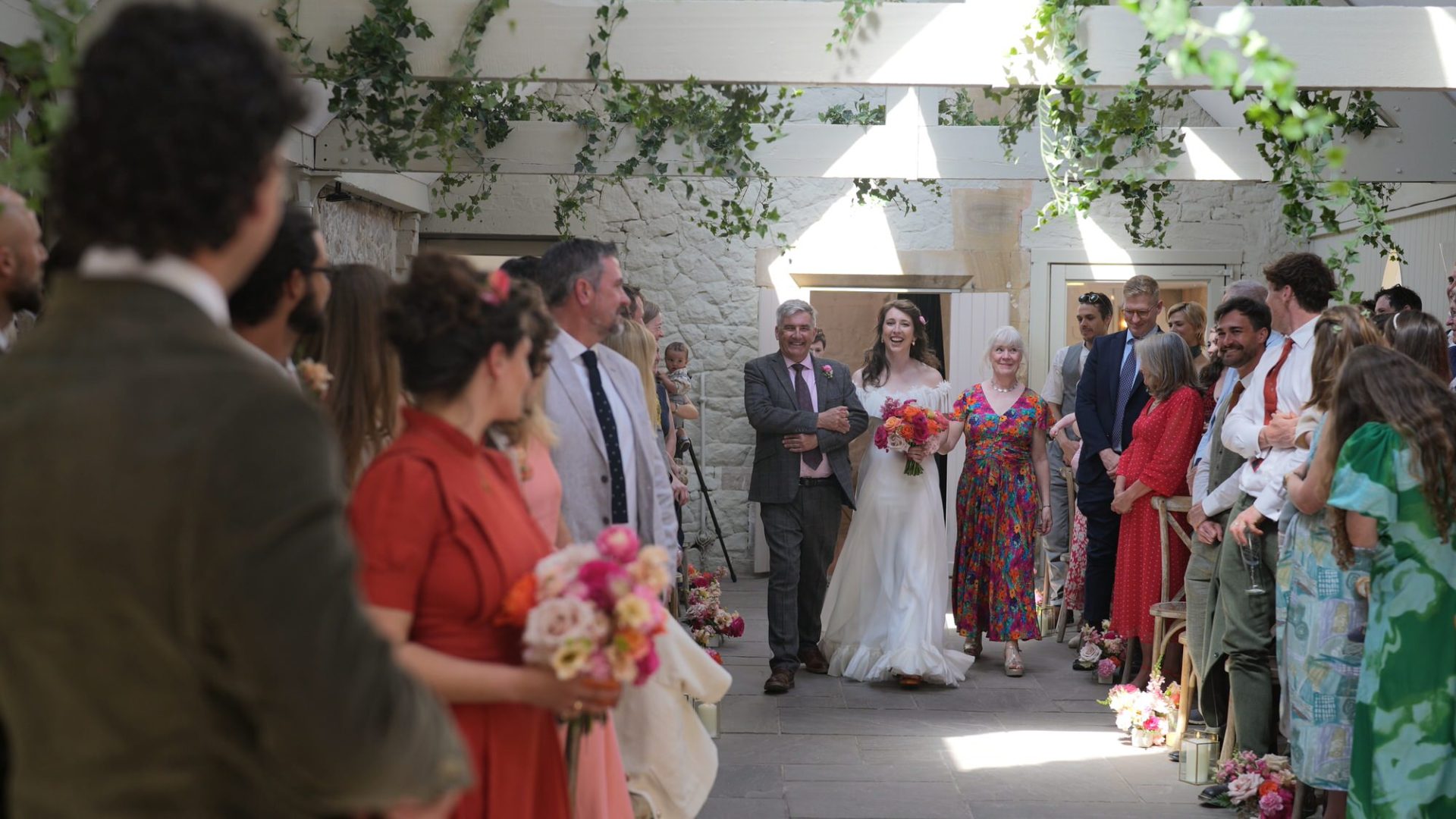 an excited bride walks down the aisle in the ceremony room at Wyresdale Park