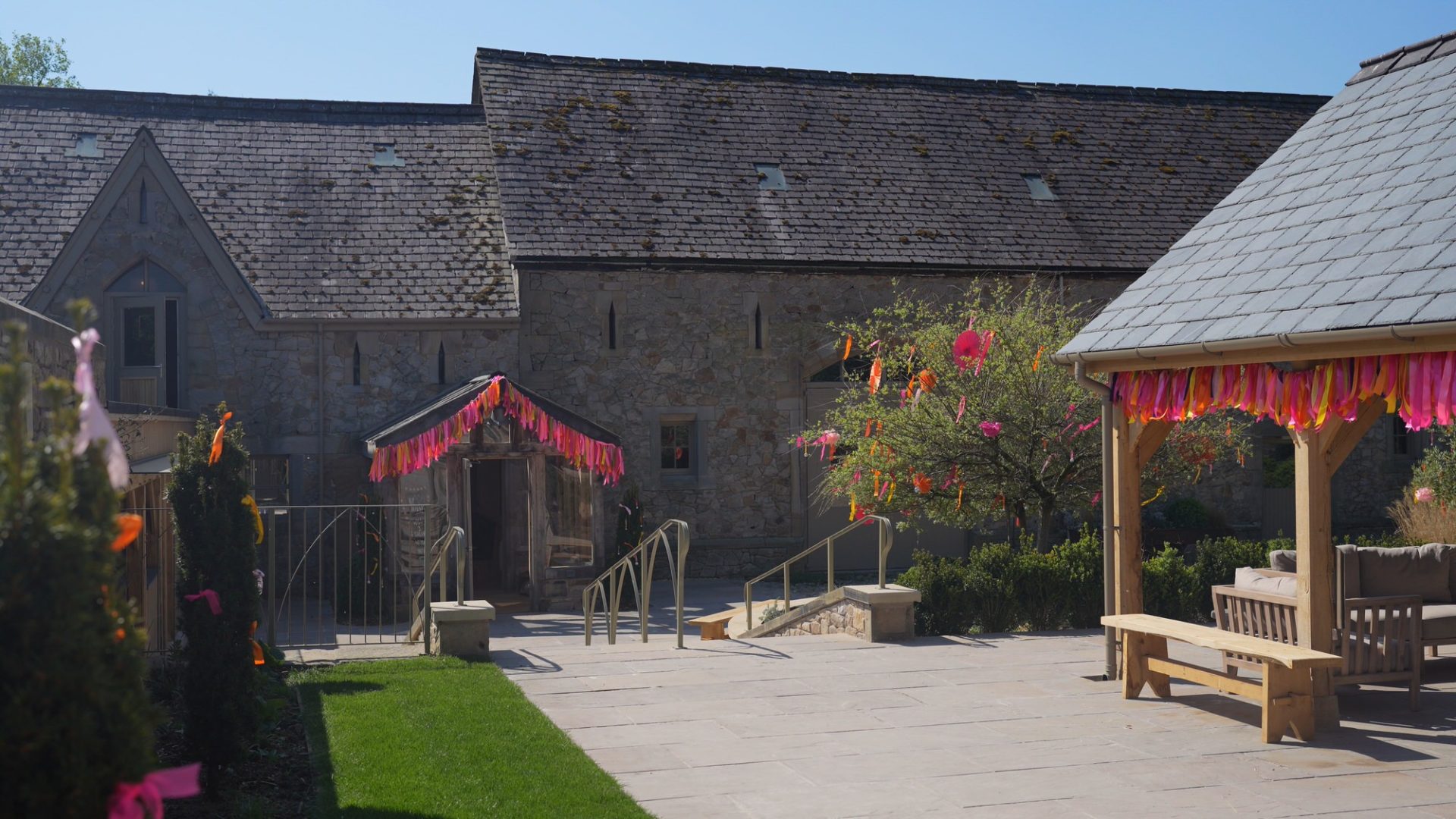 video still of outside Wyresdale weddings courtyard with tropical garlands hanging in the summer breeze