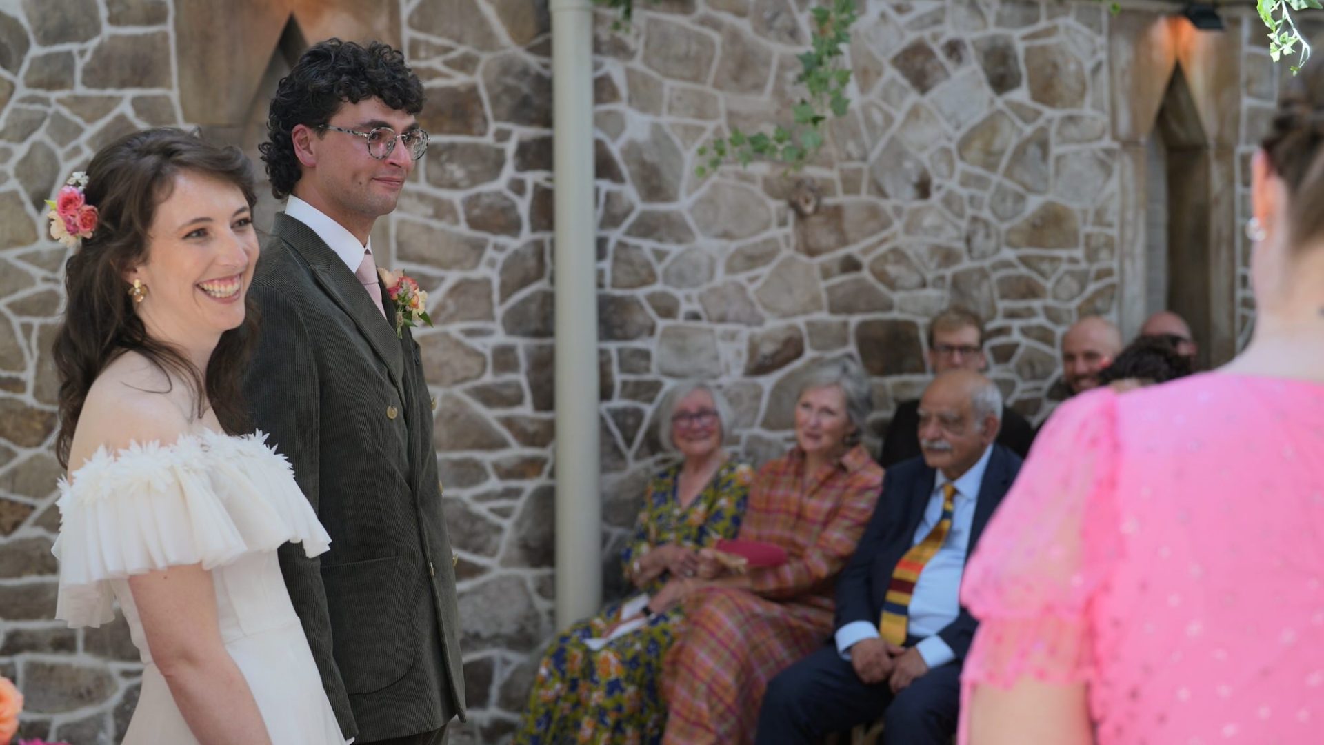 guests laugh along with Hazel the rainbow celebrant and couple