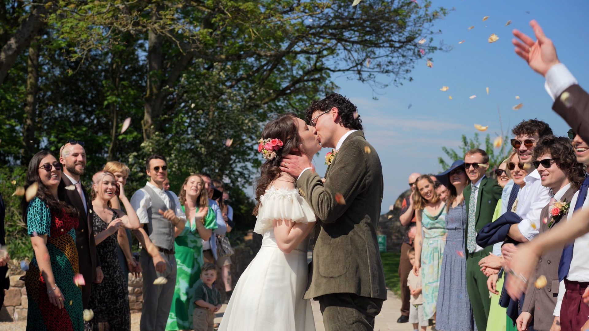 a newly married couple kiss during confetti at Wyresdale Park
