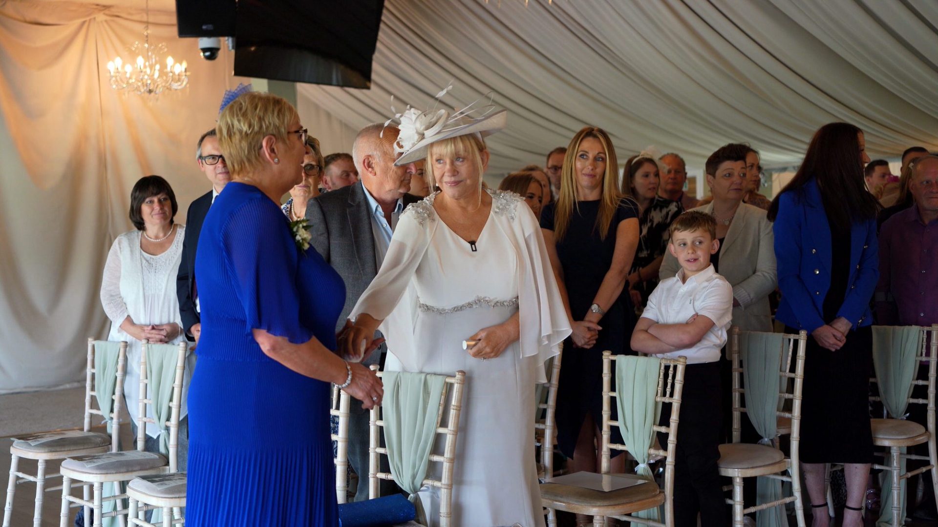 a mum hands the brides mum a tissue during the emotional wedding ceremony at The Moorlands Inn Halifax