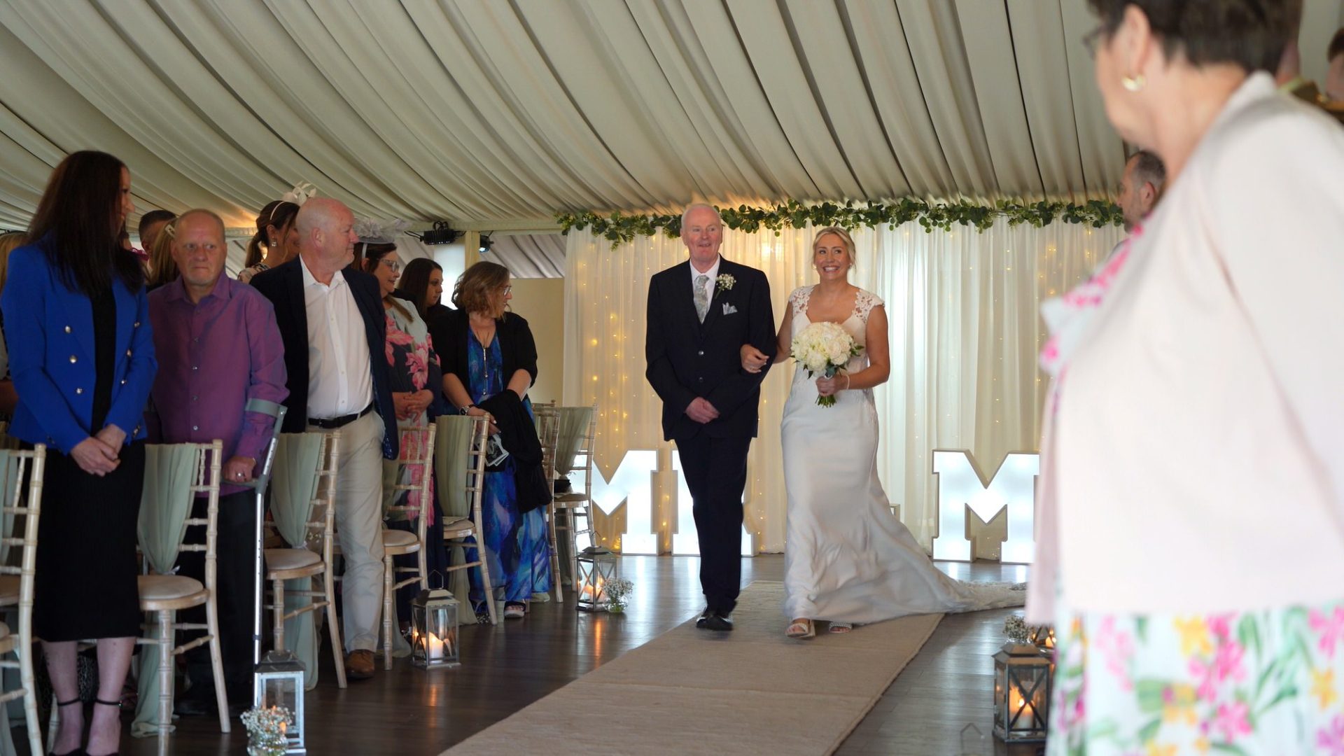 a bride walks down the aisle with her dad