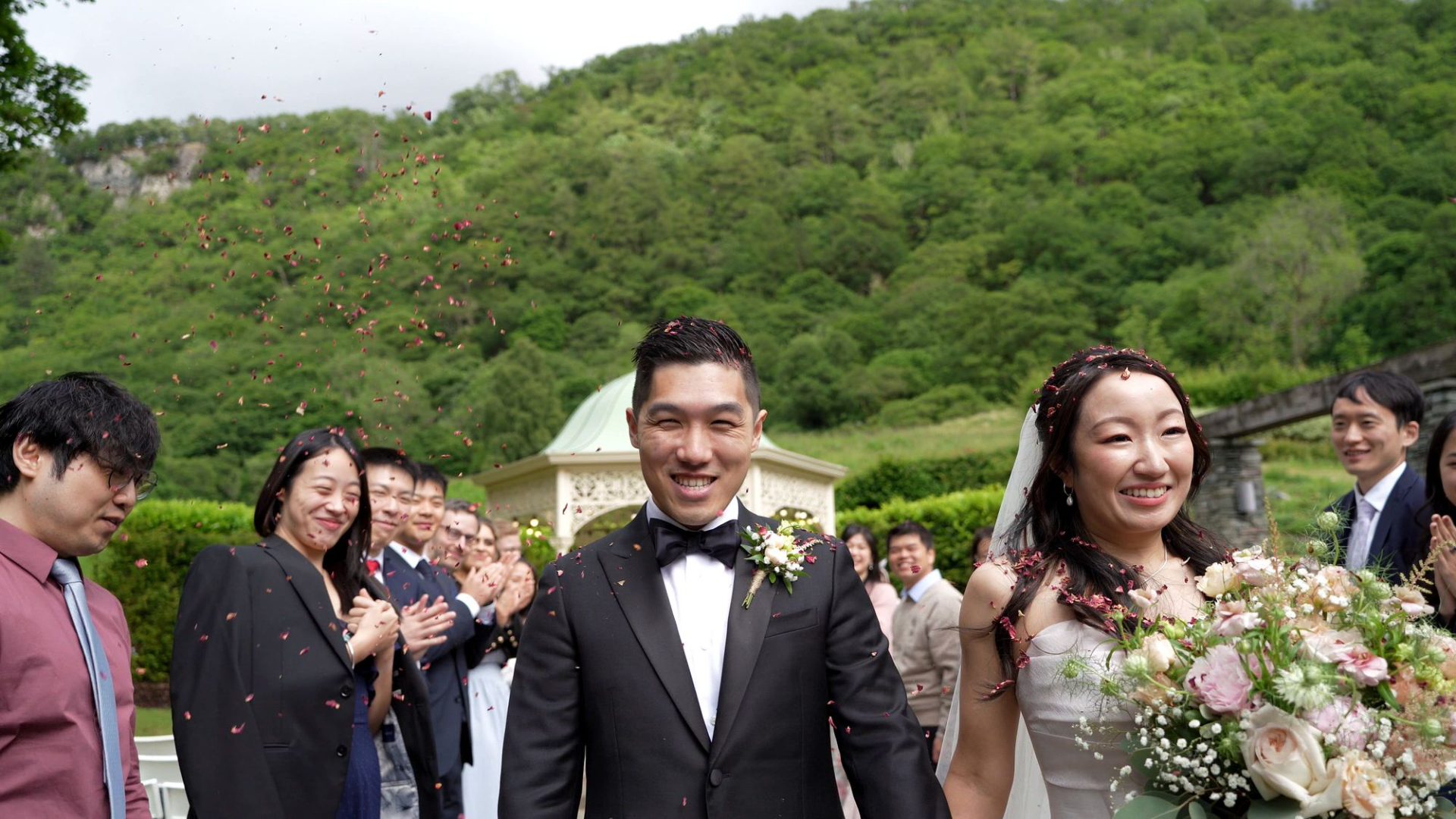 a smiling couple during their confetti walk filmed outside lodore falls hotel