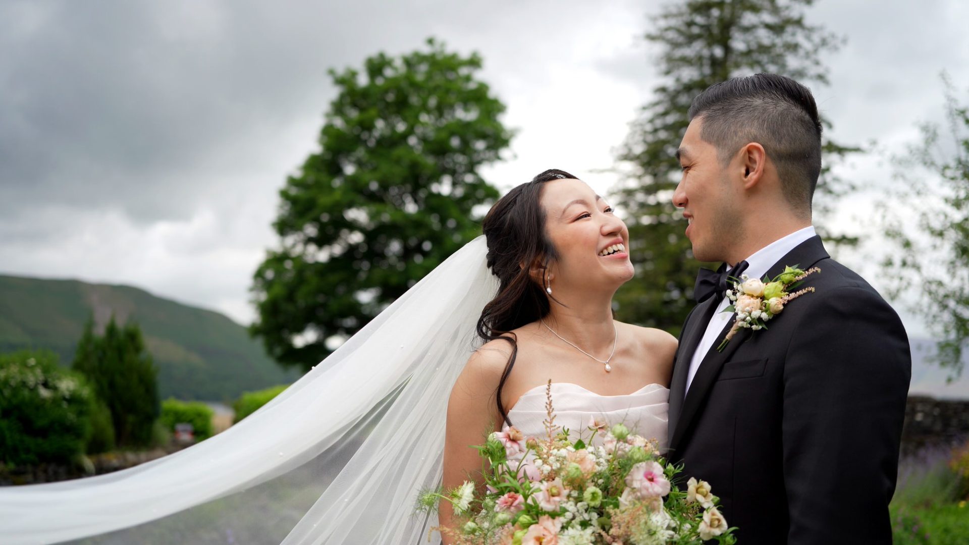 a couple pose by the river at Lodore Falls Hotel