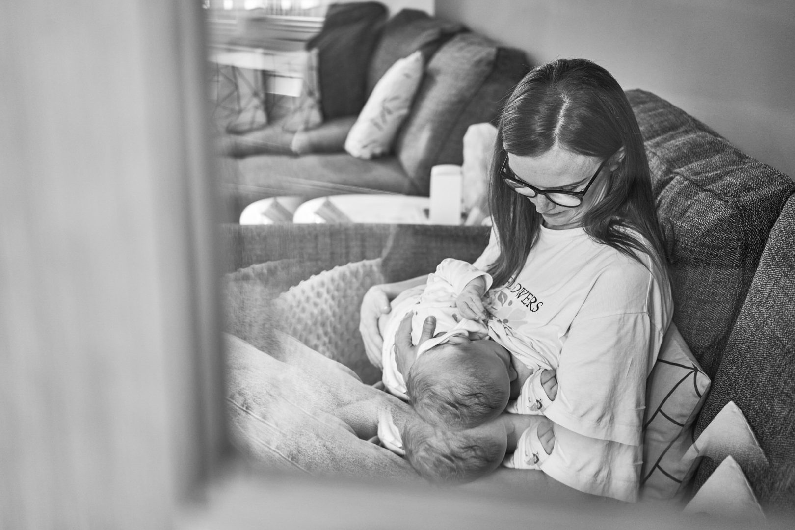 a discreet and candid photo of a mum breastfeeding her baby at home