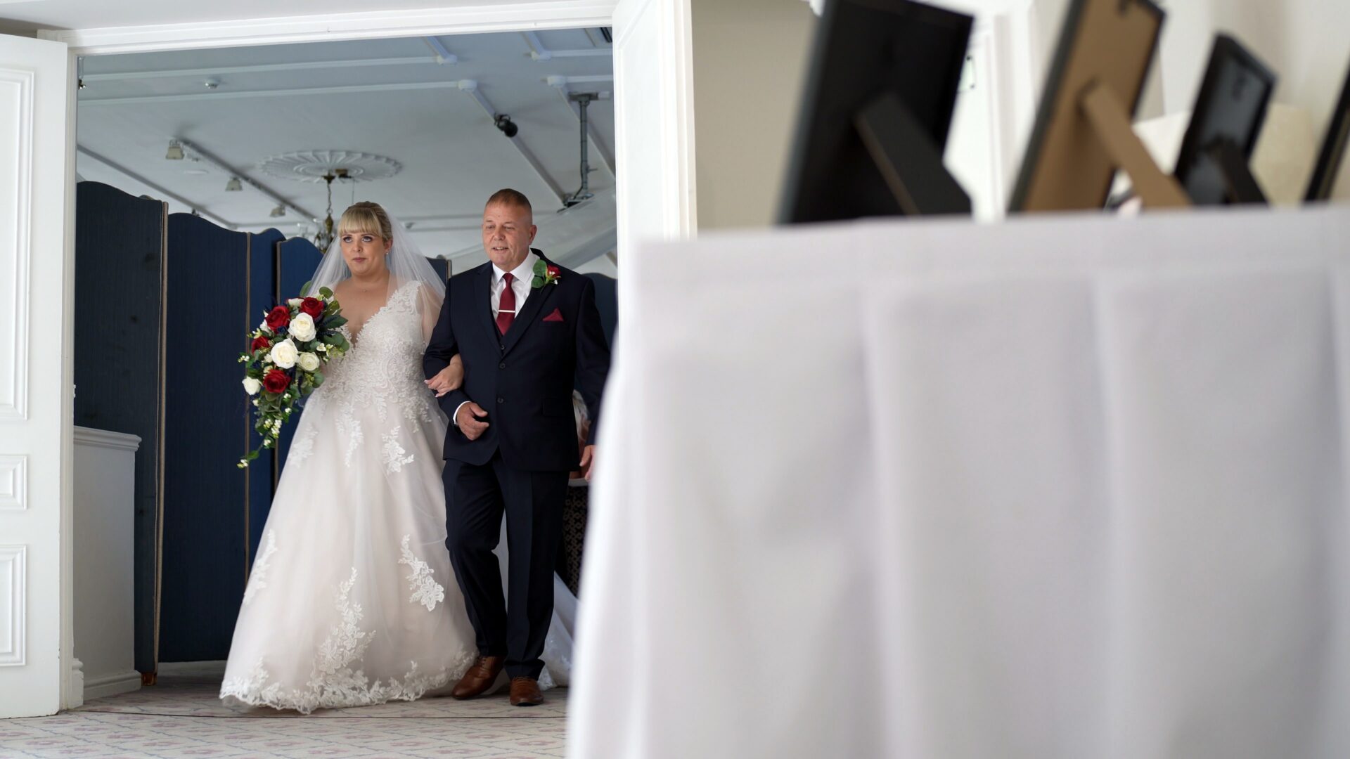 the bride looks up just before she walks down the aisle at an indoor ceremony at Statham Lodge Hotel in Cheshire