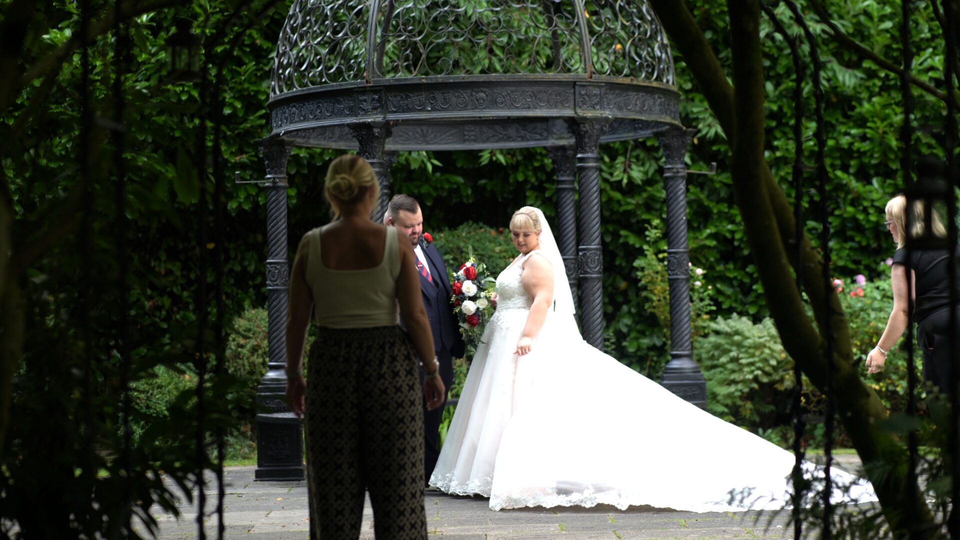 photographers get the couple in to position for their photos in the gardens at Statham Lodge Hotel in Cheshire