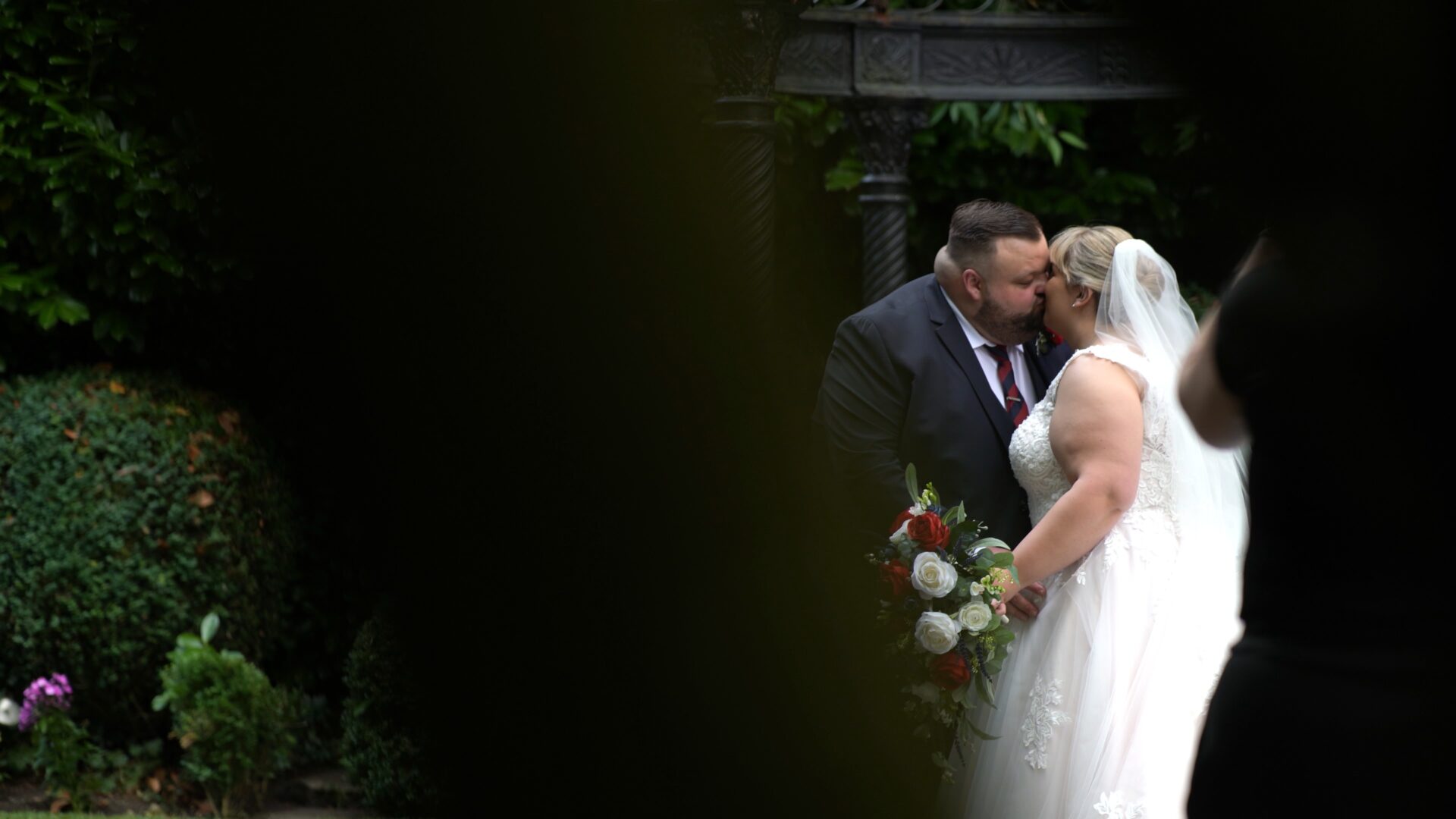 a candid video still of a couple kissing in the gardens at Statham Lodge Hotel in Cheshire