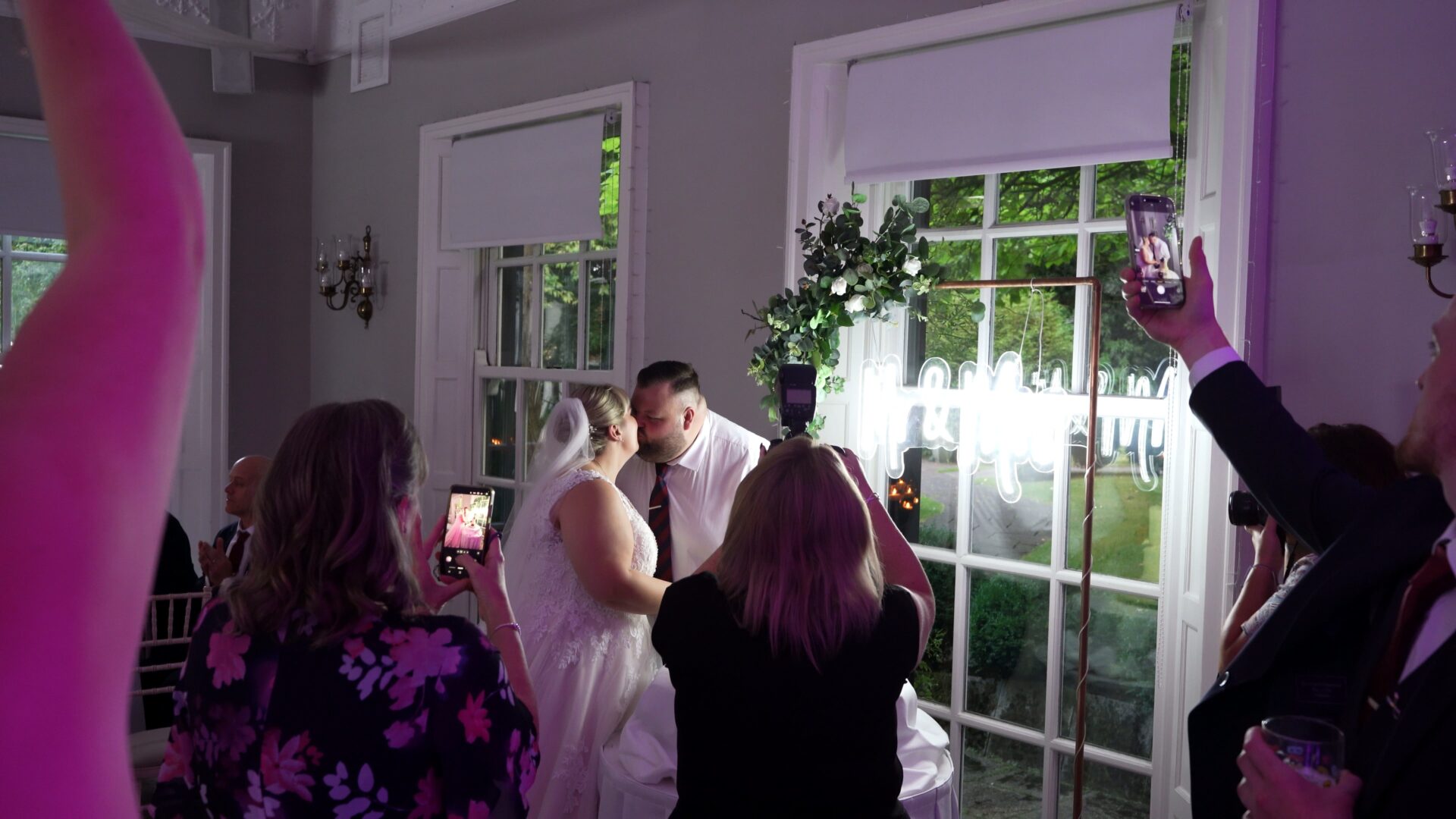 a creative real moment captured by the videographer of guests and the photographers capturing the cake cutting