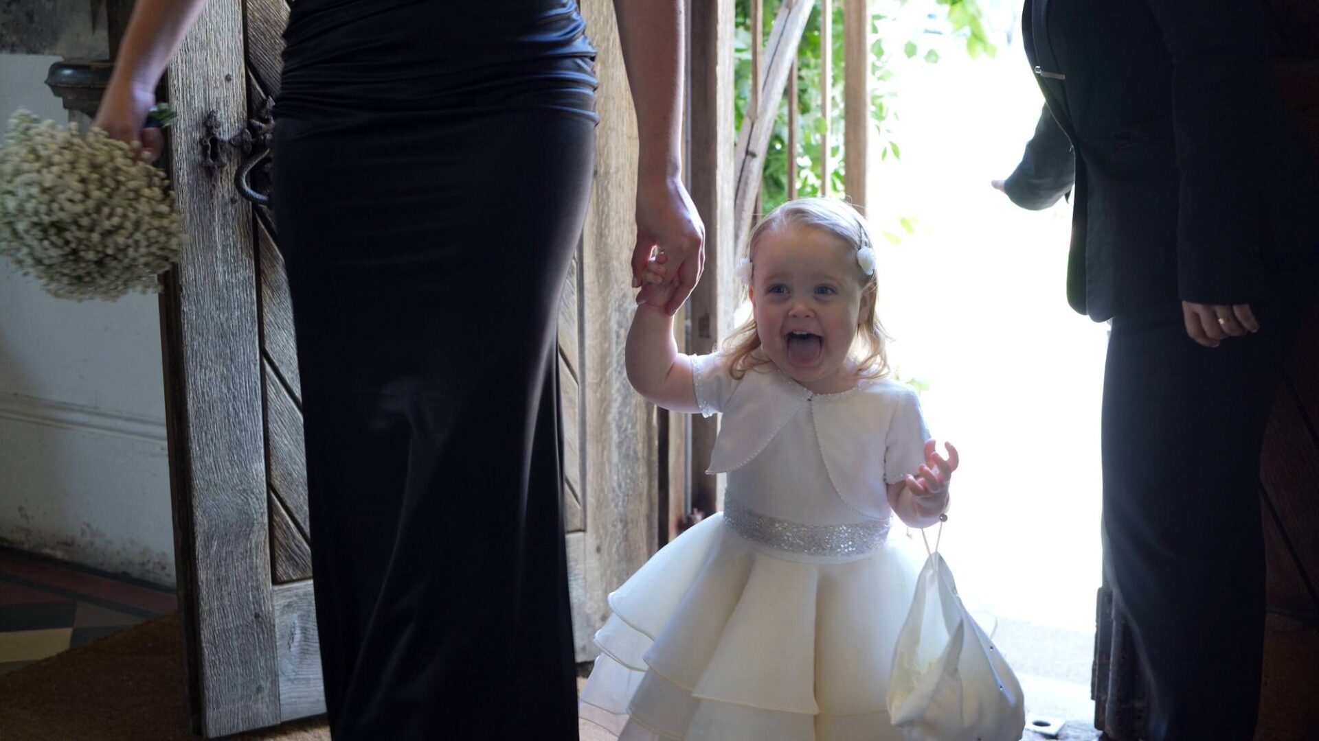 an excited flowergirl walks into the chapel at Rudding Park Harrogate