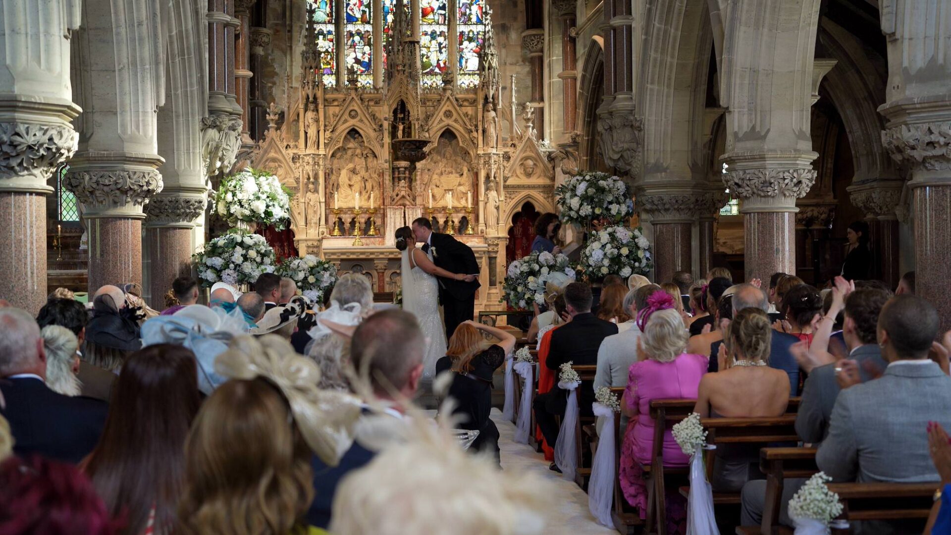 a video still from the back of the chapel as the couple have their first kiss