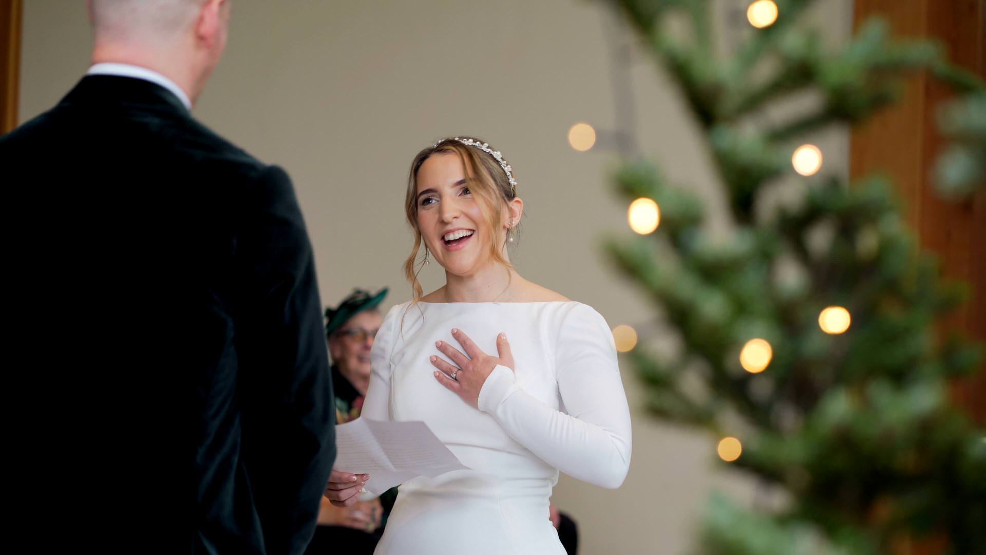 a bride reads her personal vows during a festive wedding at the Out Barn