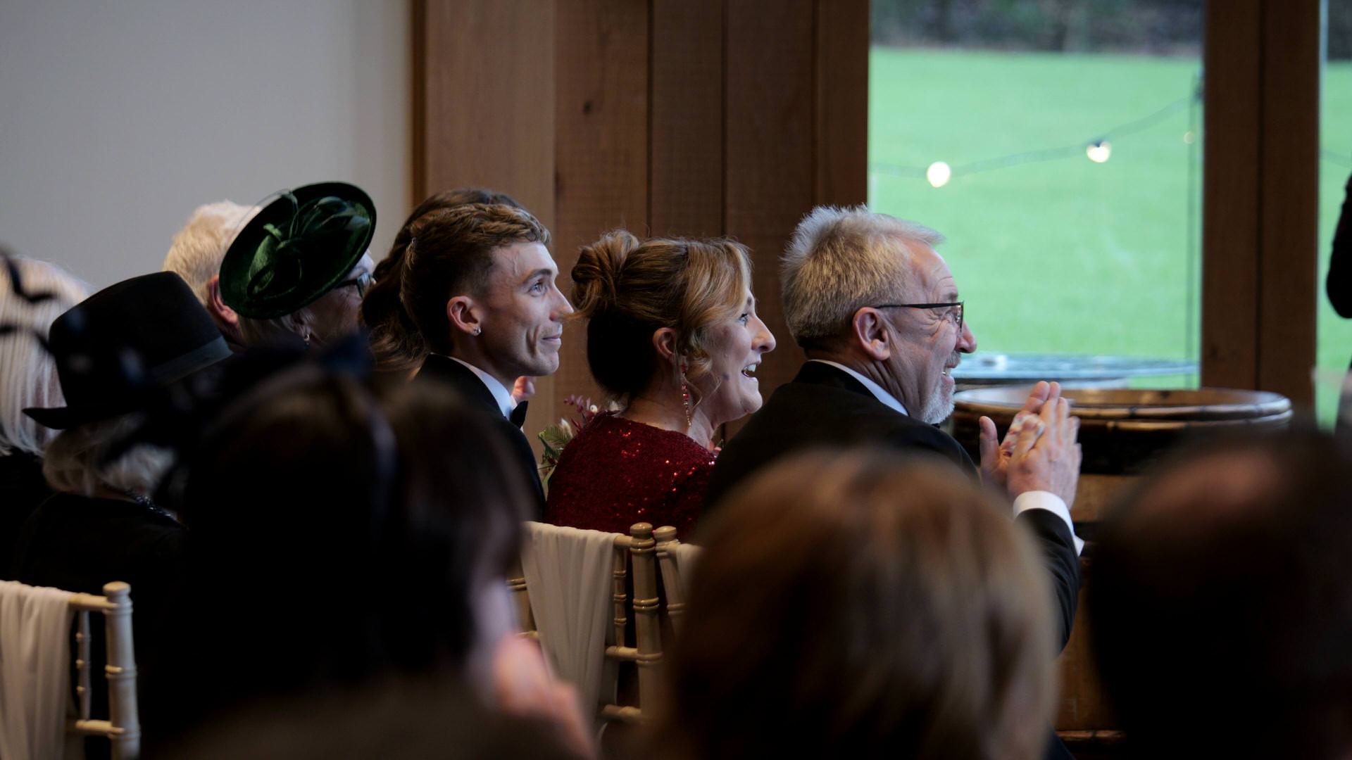 guests clap and smile during wedding ceremony