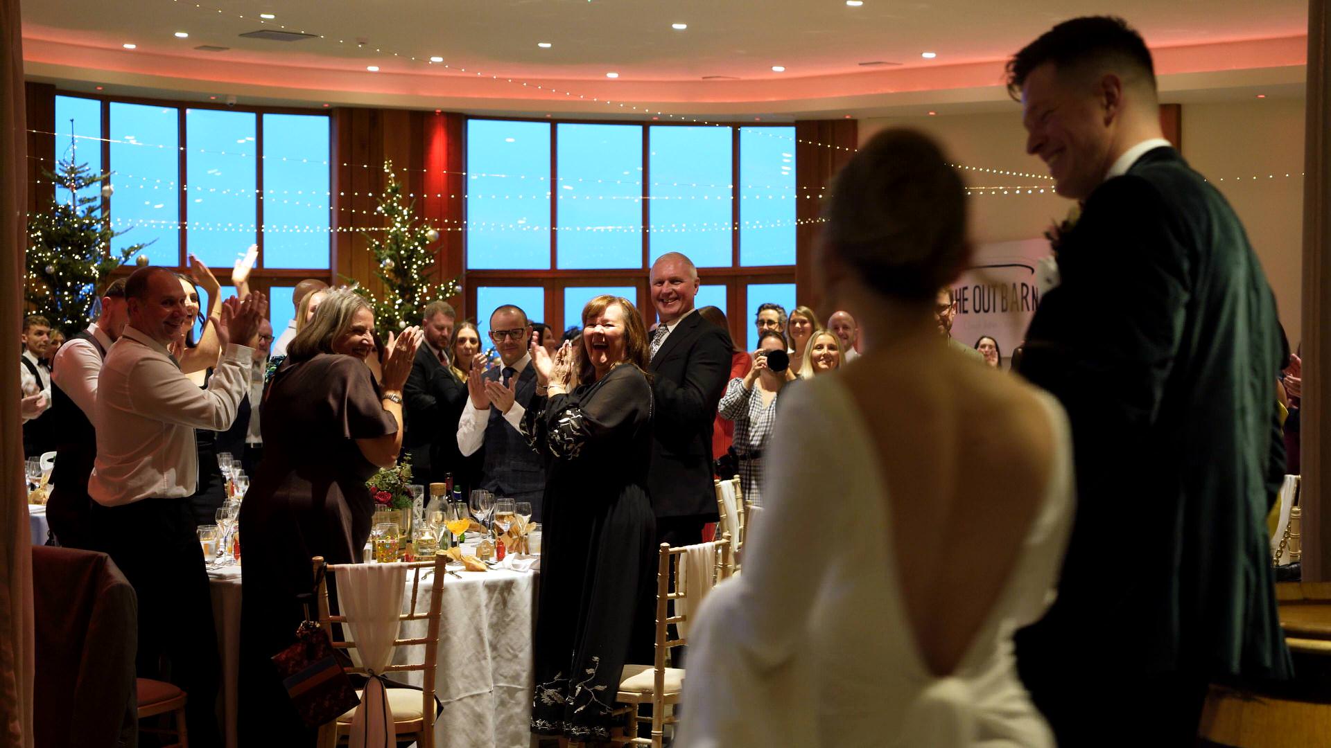 a couple are announced into the oval room at the Out Barn for their wedding breakfast