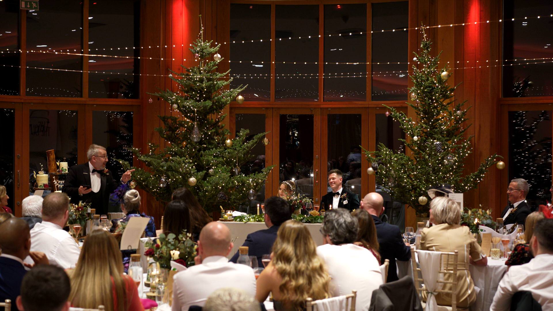 speeches in front of the Christmas trees for a festive wedding at the Out Barn