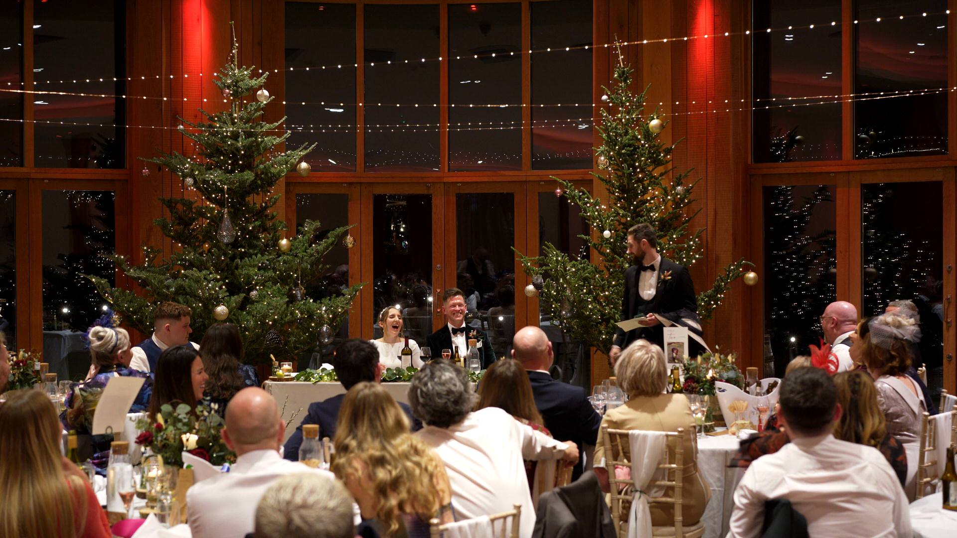 the couple and guests laugh during speeches at the Out Barn