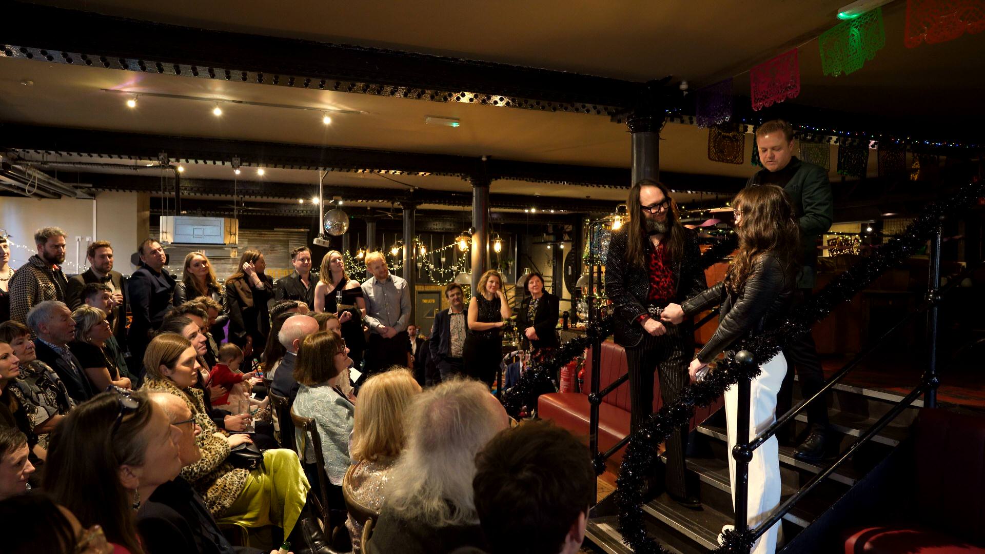 a tender moment captured on video of the bride reaching for her grooms hand during the relaxed ceremony