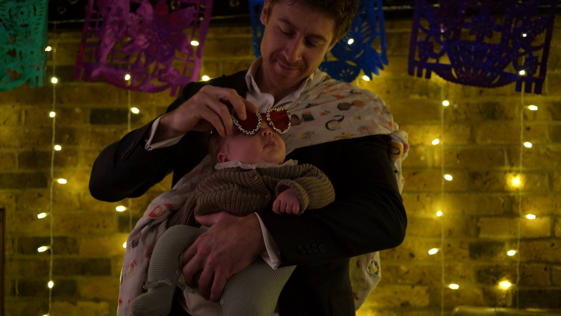 a guest puts funny glasses on their baby