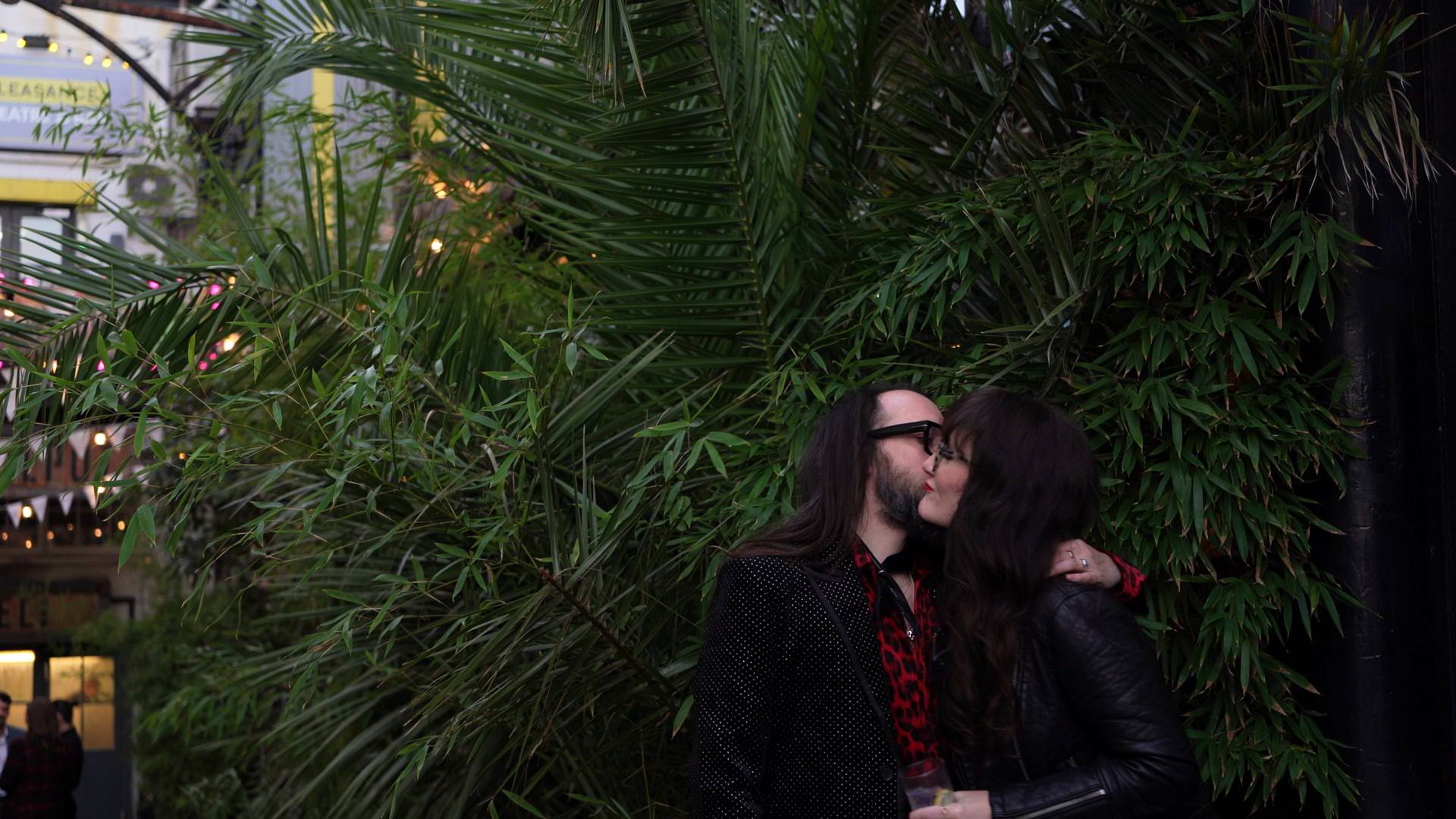 the couple have a kiss under the palms at The Depot N7