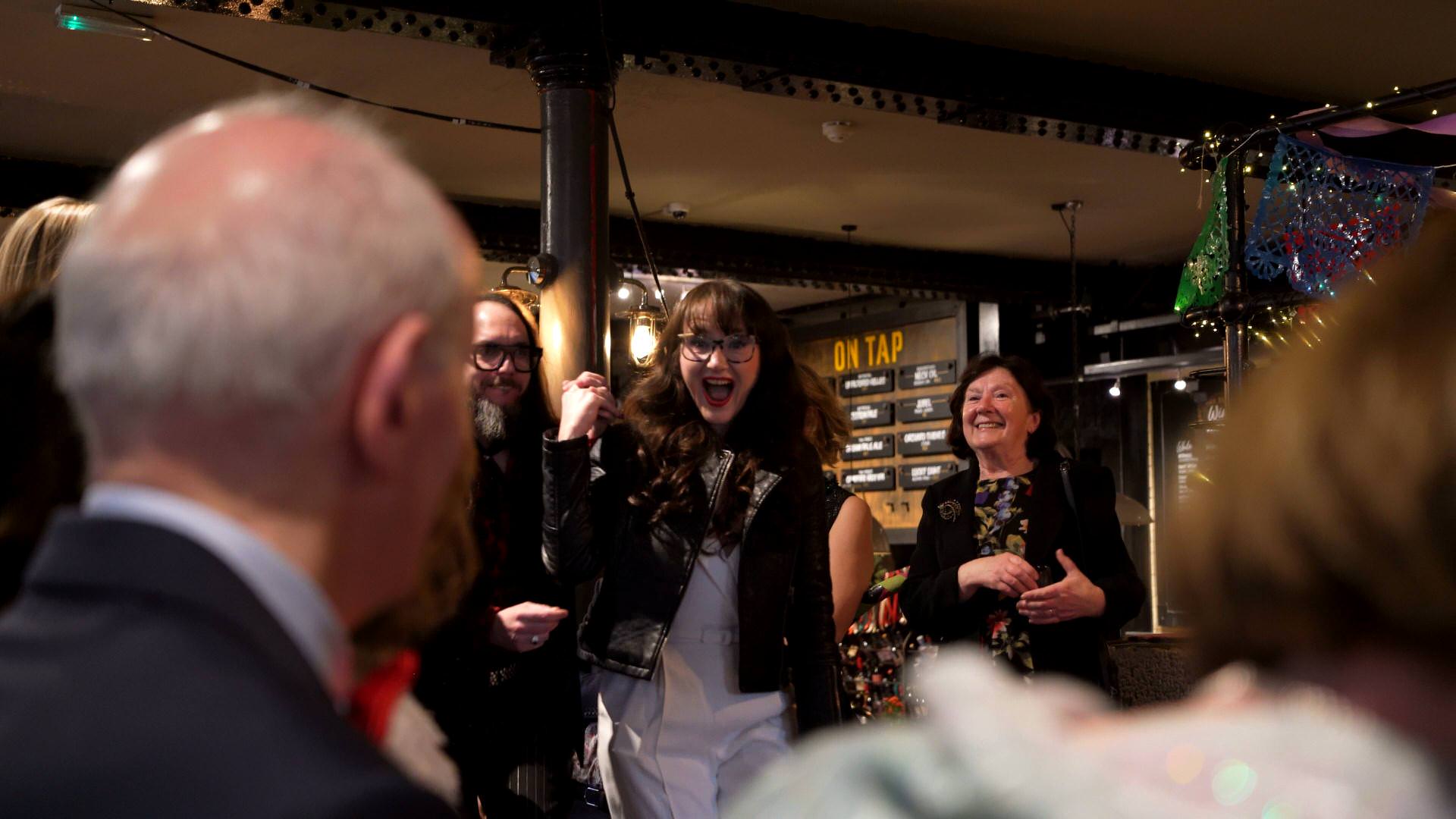 an excited bride in a leather jacket makes their fun ceremony entrance to Pink Pony Club at The Depot N7