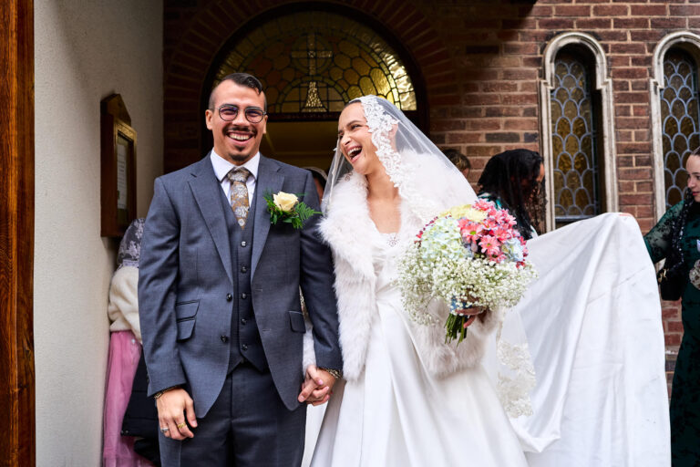 candid moment of newlyweds leaving Our Lady of Victories Catholic Church Preston