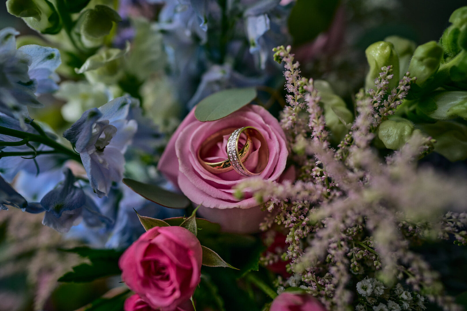 wedding rings sit inside a wedding boquet