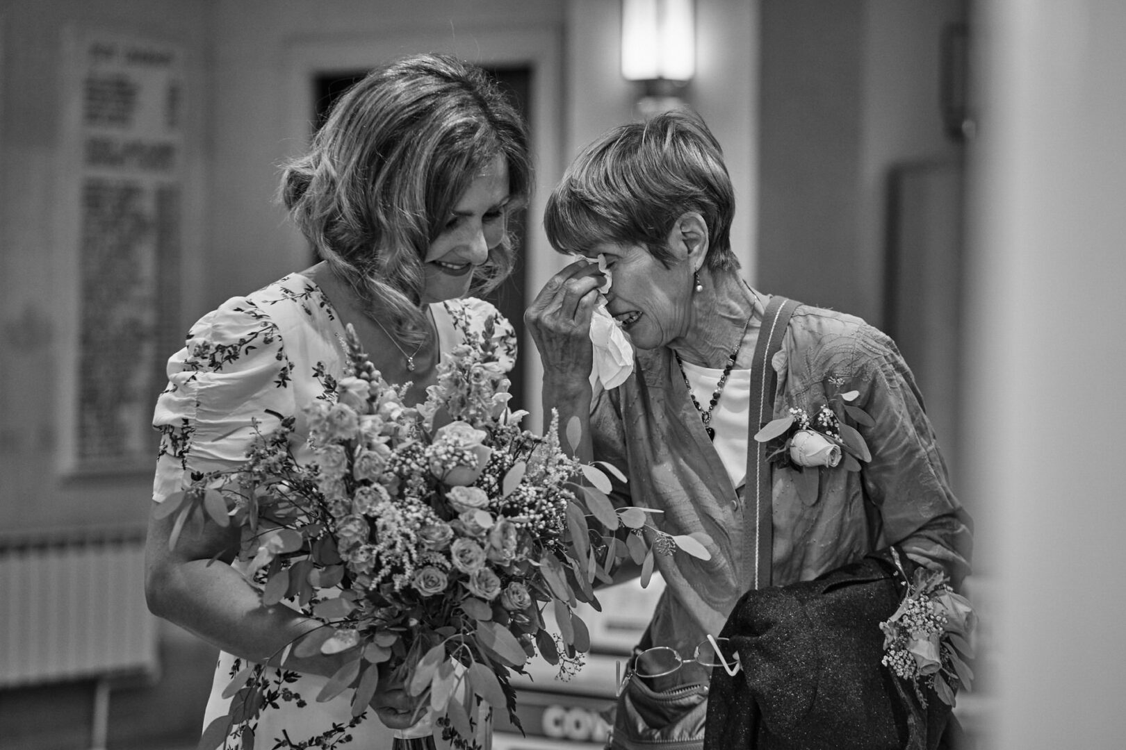 a documentary natural photo of the bride and her Mum wiping tears away before her ceremony at Ormskirk registry office