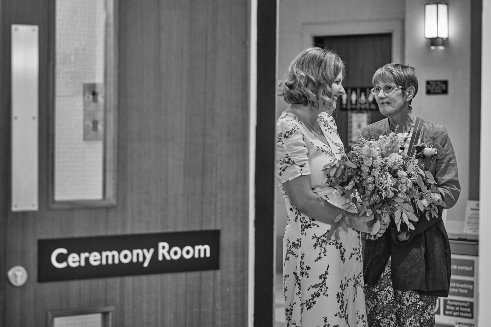 the bride and her mum share a moment outside the ceremony room before their small wedding at Ormskirk registry office