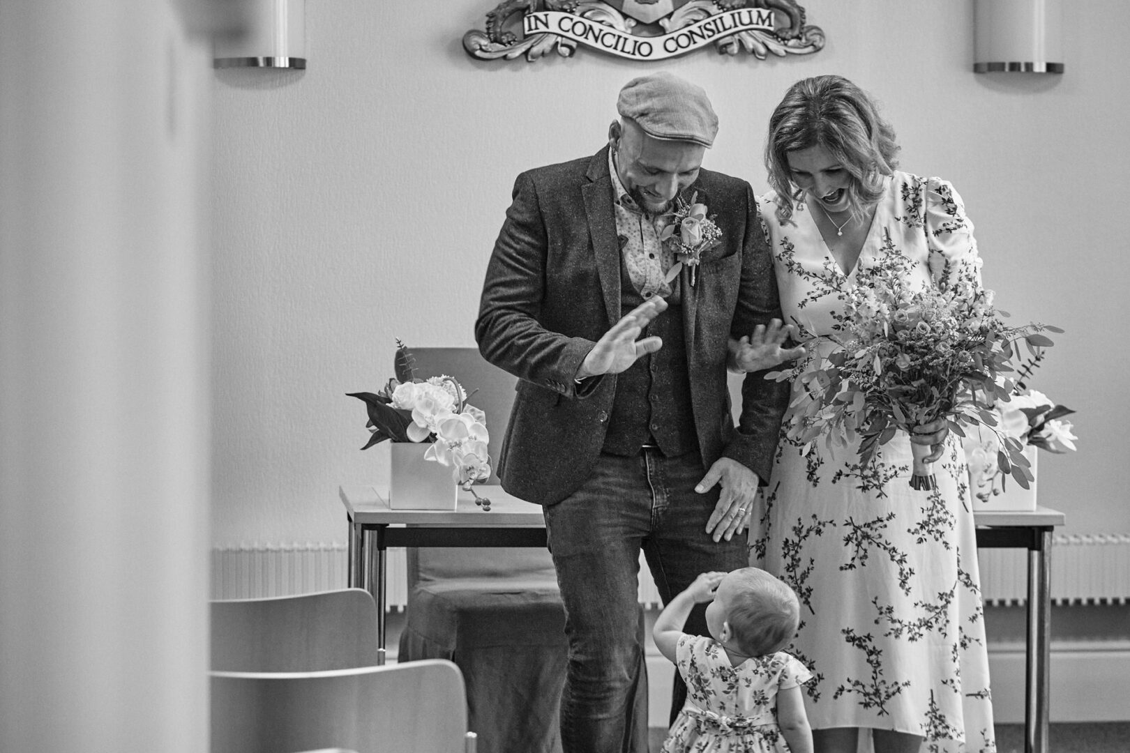 a couple get ready to walk down the aisle and wave to their toddler in Ormskirk