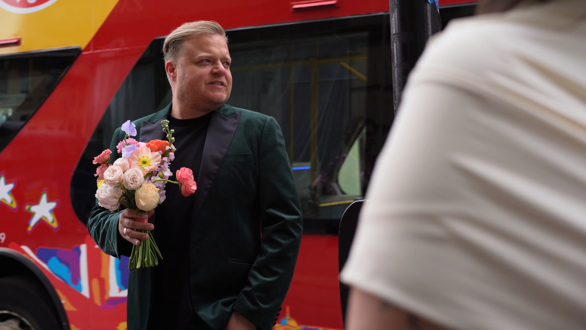 Groomsmaid stands with bouquet in the streets of Bath