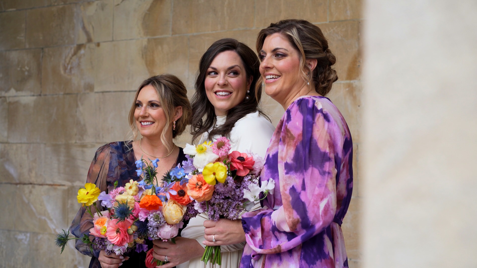 videographer captures bride smiling at her Sister during photos