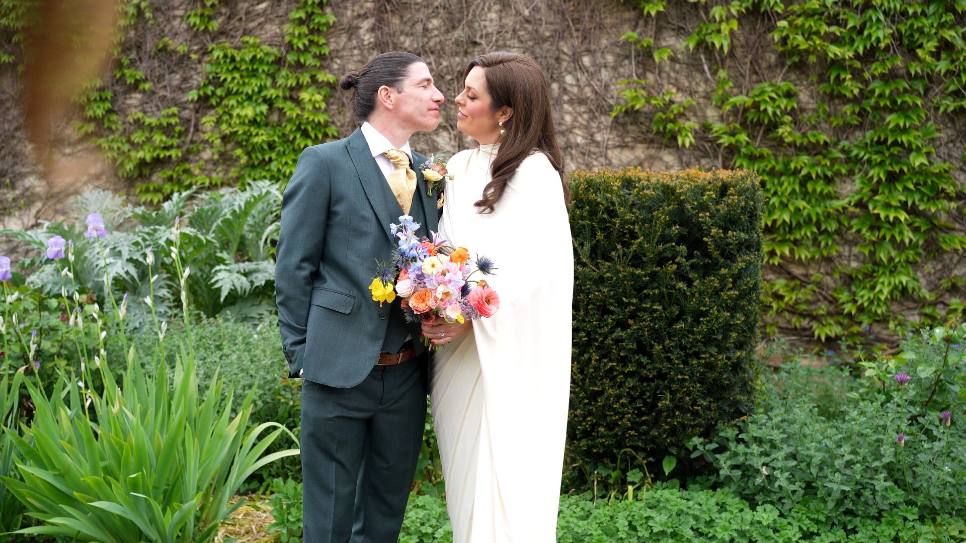 a couple smile at each other posing in gardens in Bath