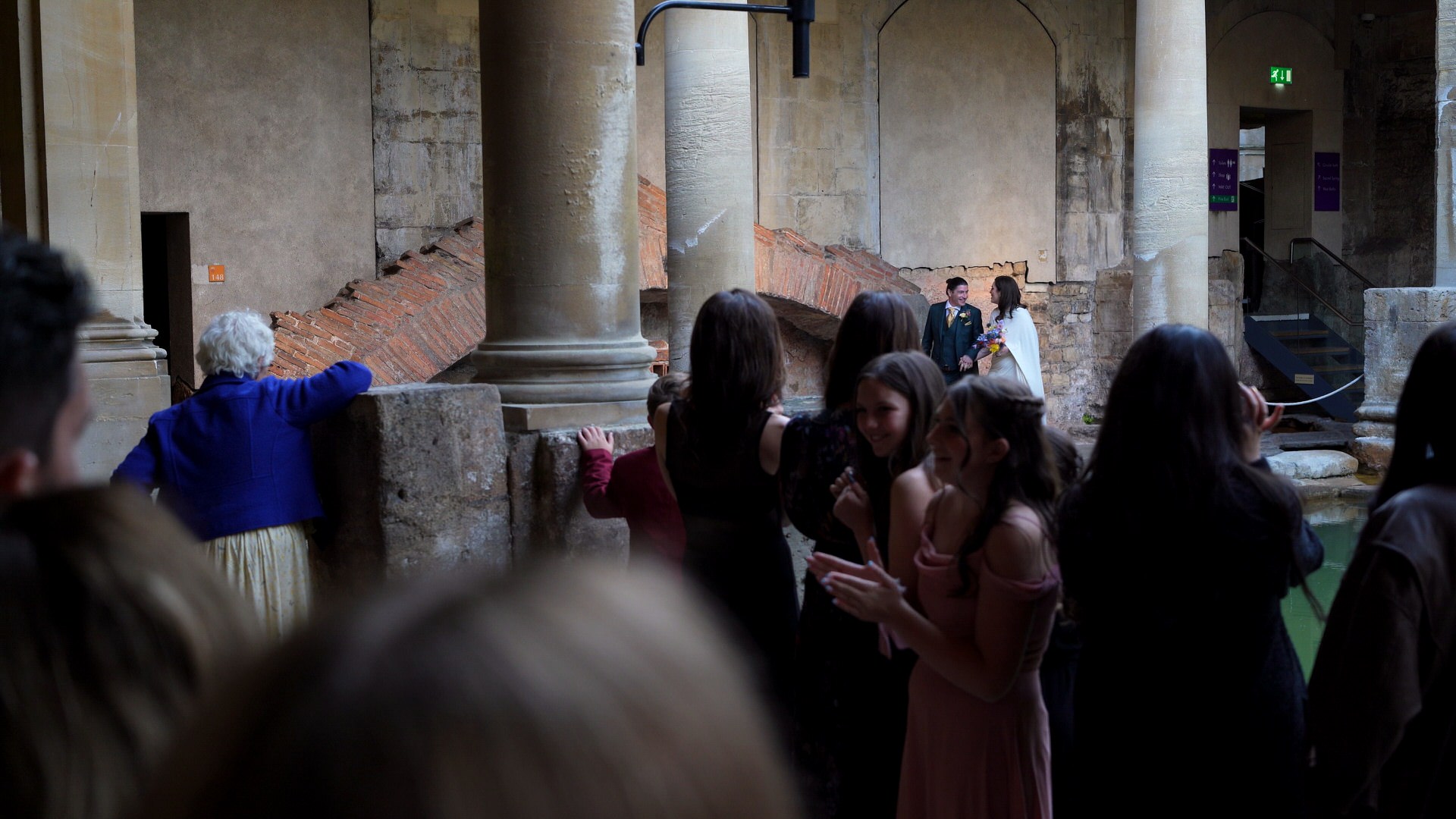 a couple make their entrance during an evening vow renewal at The Roman Baths