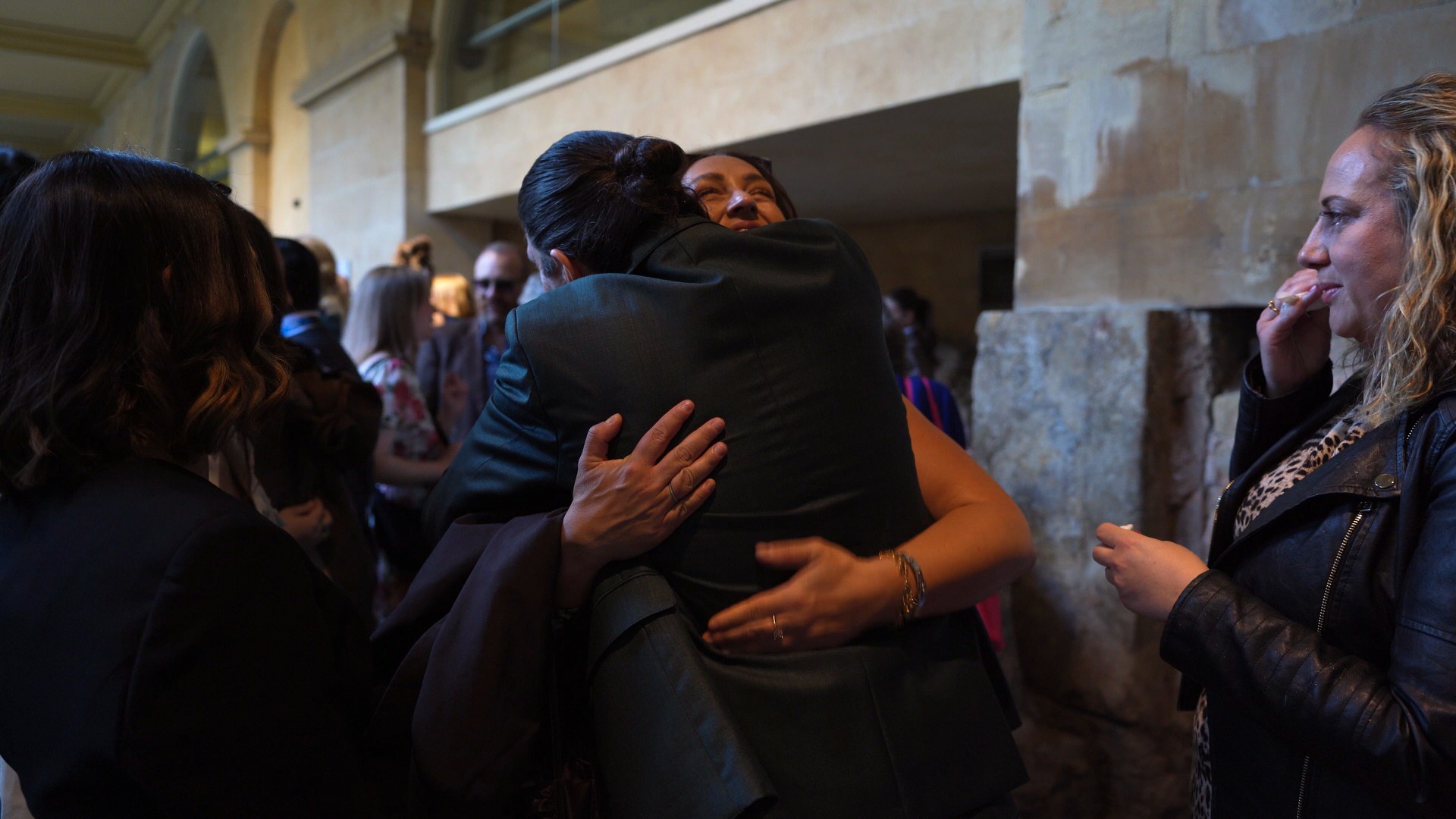 the groom gets a big hug from a guest