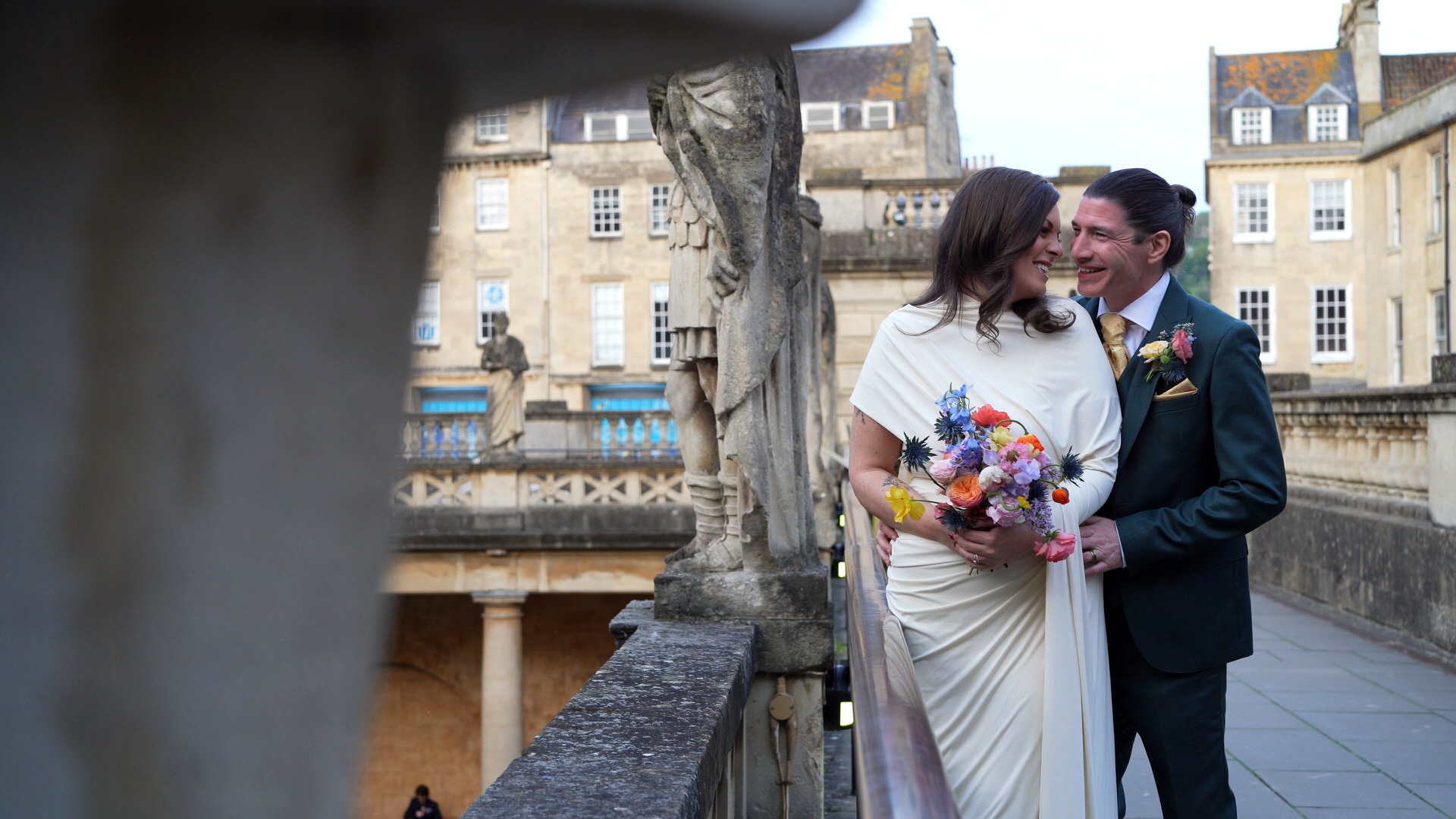 a couple cuddle in together for natural photos on the terrace at Roman Baths