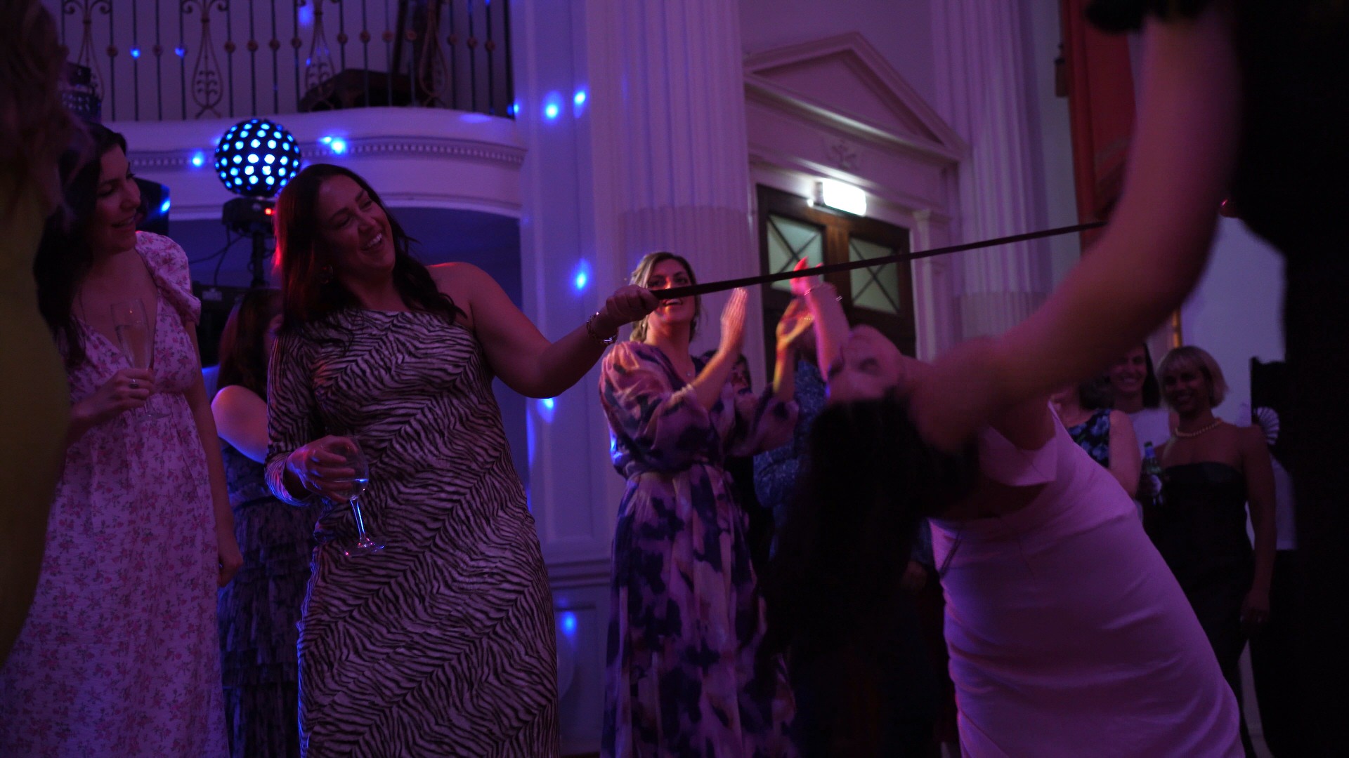 guests start a limbo on the dancefloor with a belt