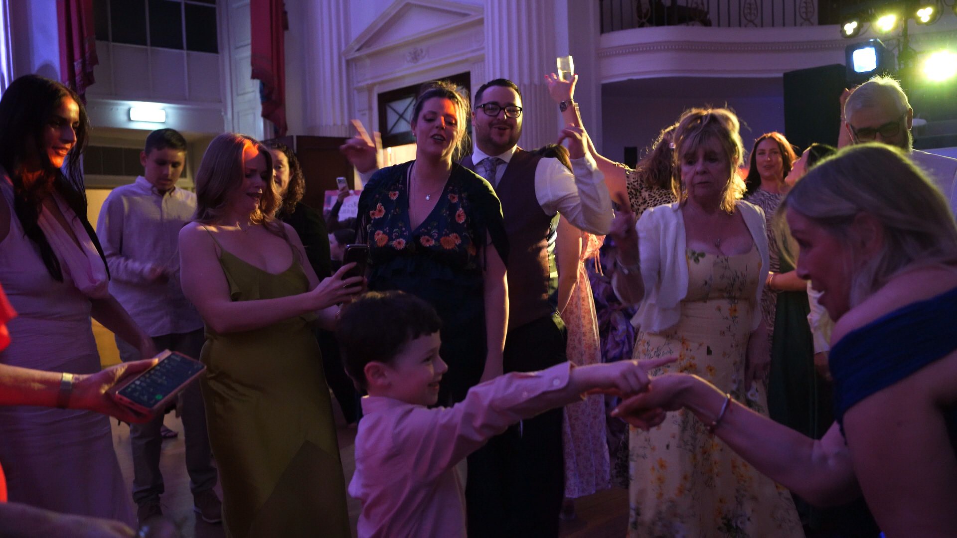 guests sing along with a young boy on the dancefloor at the Pump Room