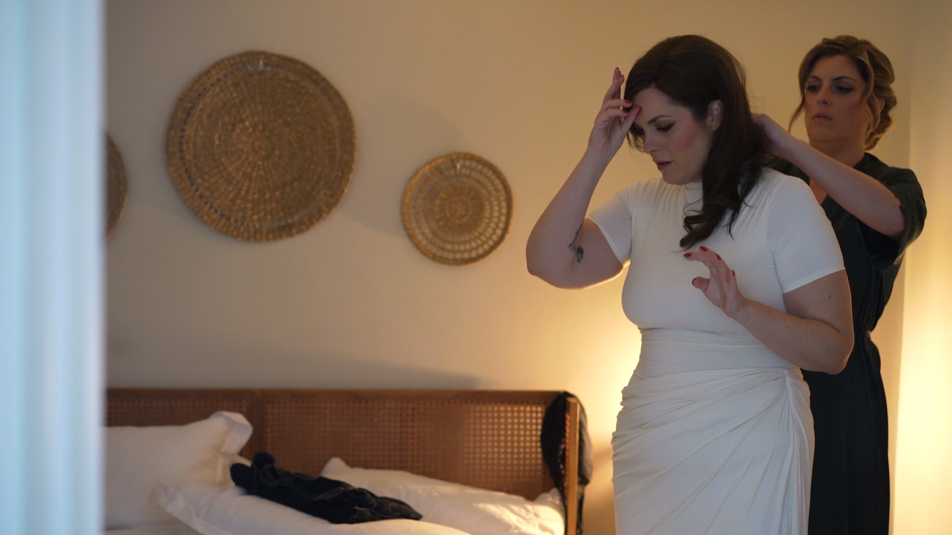 Katie gets helped into her Grecian inspired ivory draped dress ahead of vow renewal