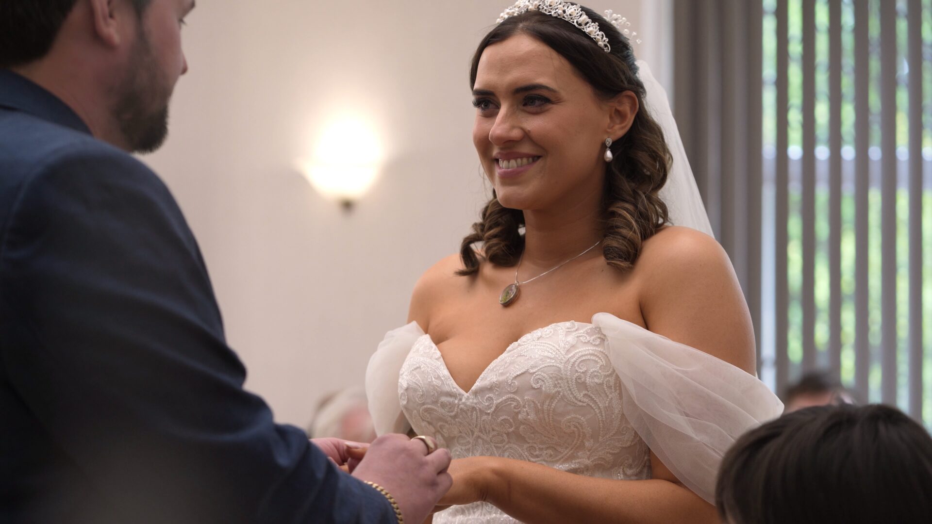 a video still of a bride smiling during the wedding ceremony at Wyre Civic Centre