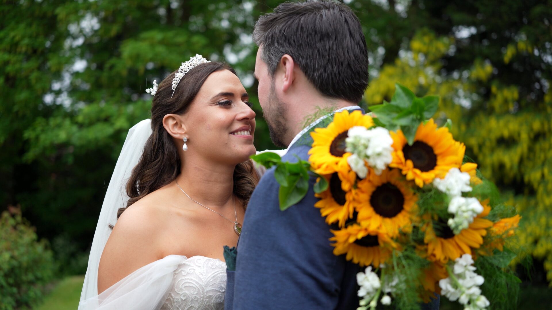 a close up of the couple enjoying a moment together holding a sunflower bouquet