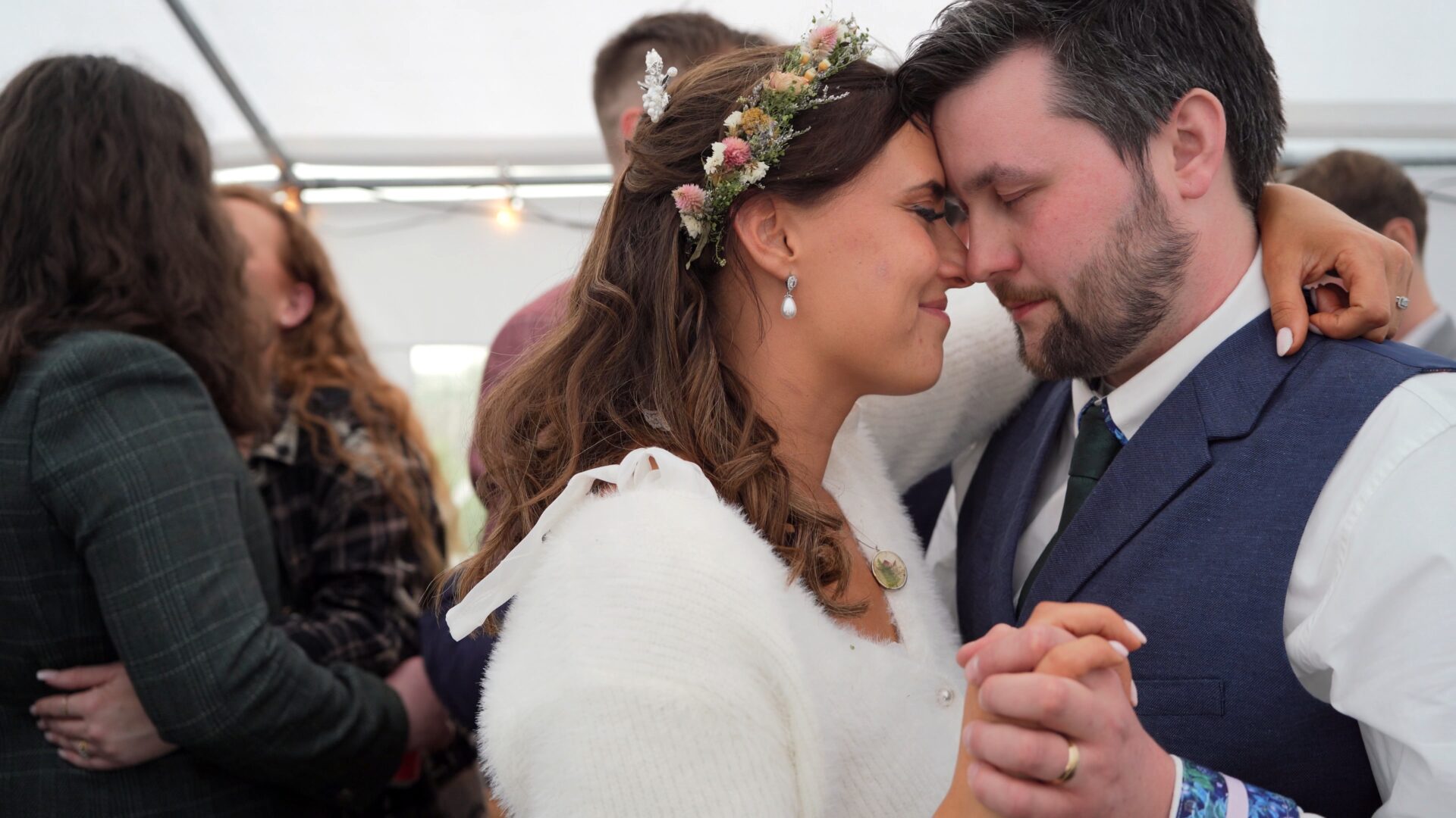 the couple snuggle during their first dance at their DIY wedding