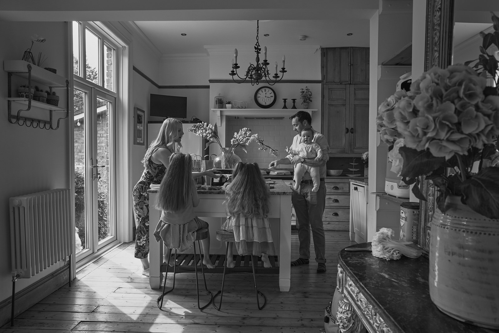 a wide documentary candid moment of a family at home in Ainsdale before a family christening in Southport